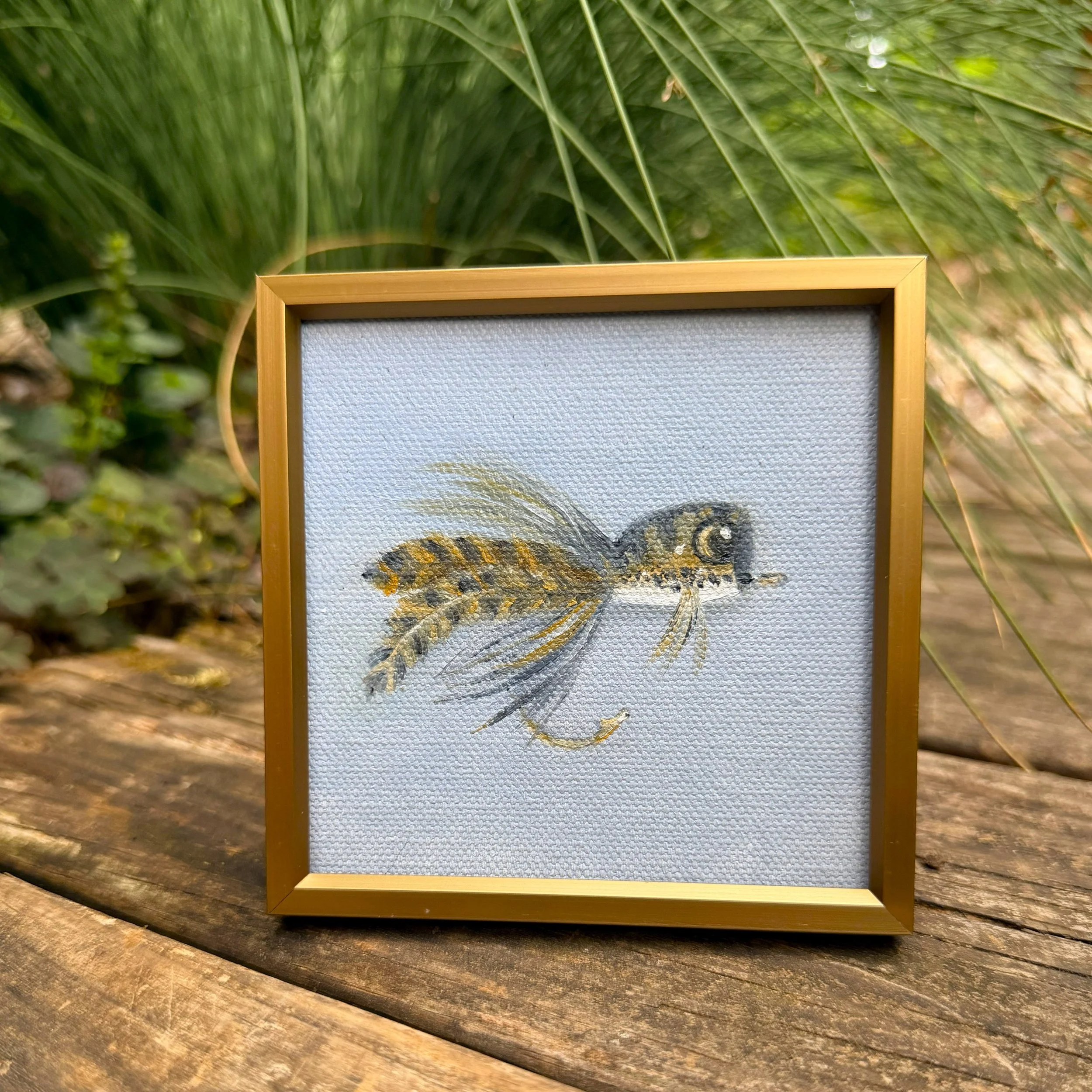 Small square fishing fly oil painting shown on canvas board, ready to frame or display as part of a collected wall.