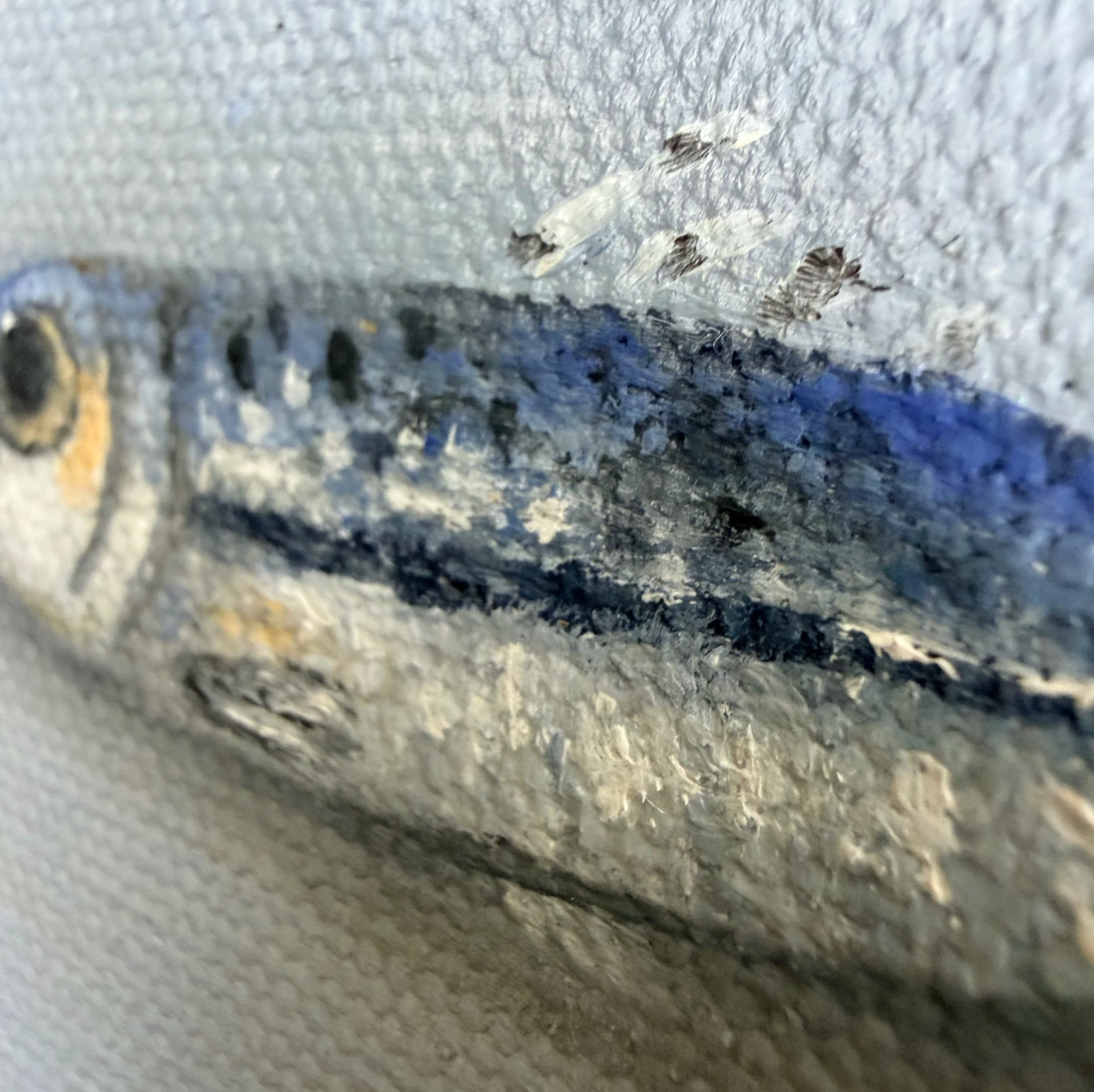 Close-up of a miniature anchovy painted in oil with reflective blue-silver highlights, a dark eye, small speckles, and visible canvas texture.