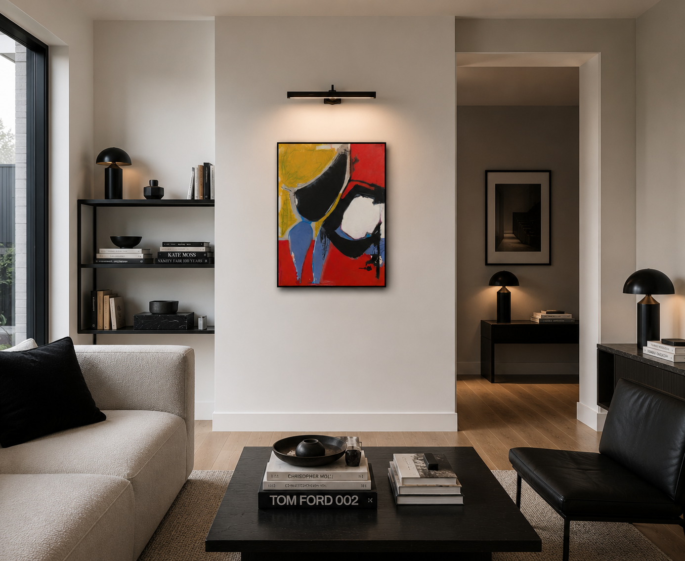 Modern living room with abstract art on wall, black shelves with books and decorative objects, black and beige furniture, and warm lighting.