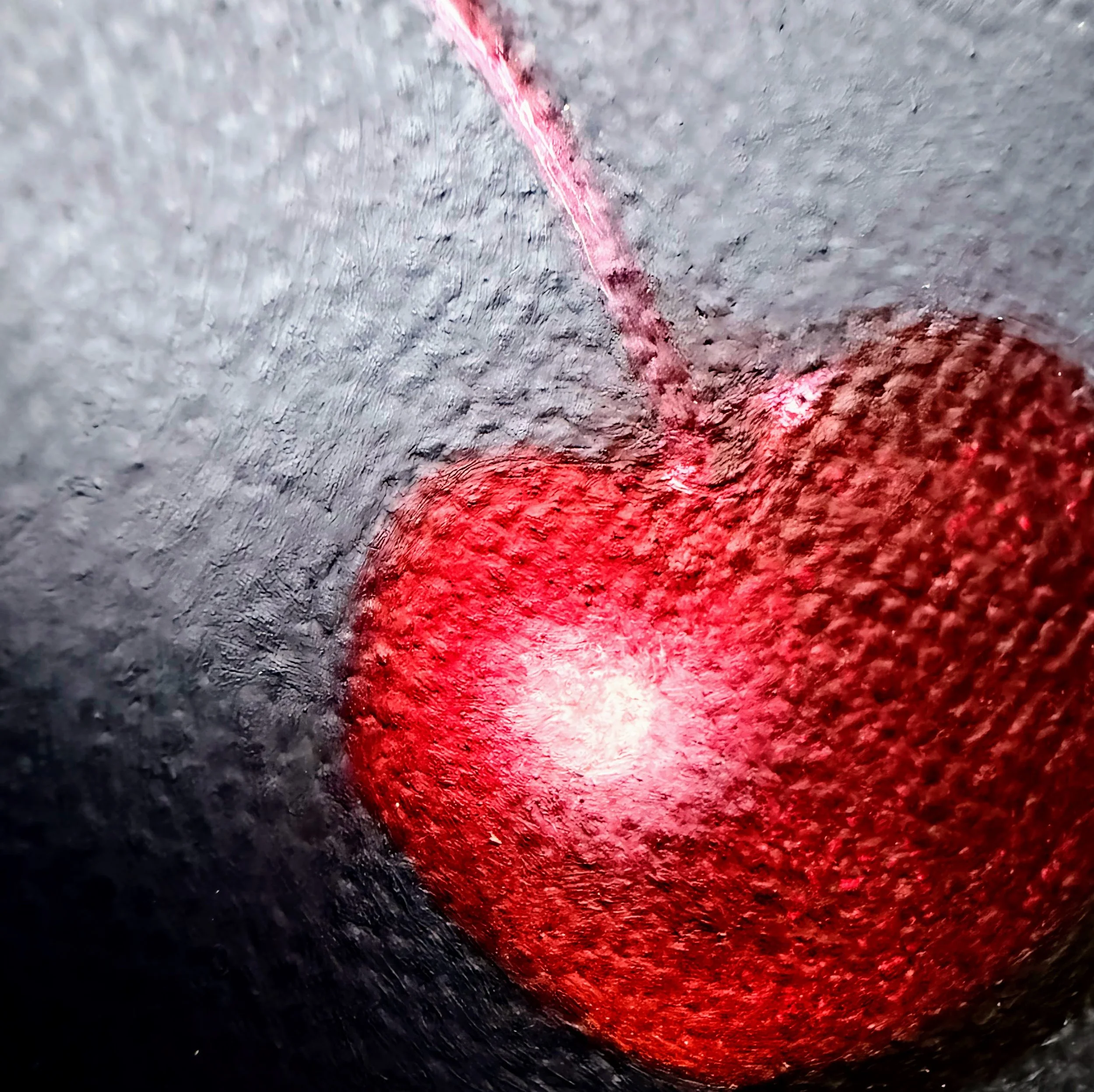 Close-up of a red cherry painted in oil with a glowing highlight, curved stem, soft shadow, and visible canvas texture against a moody dark background.