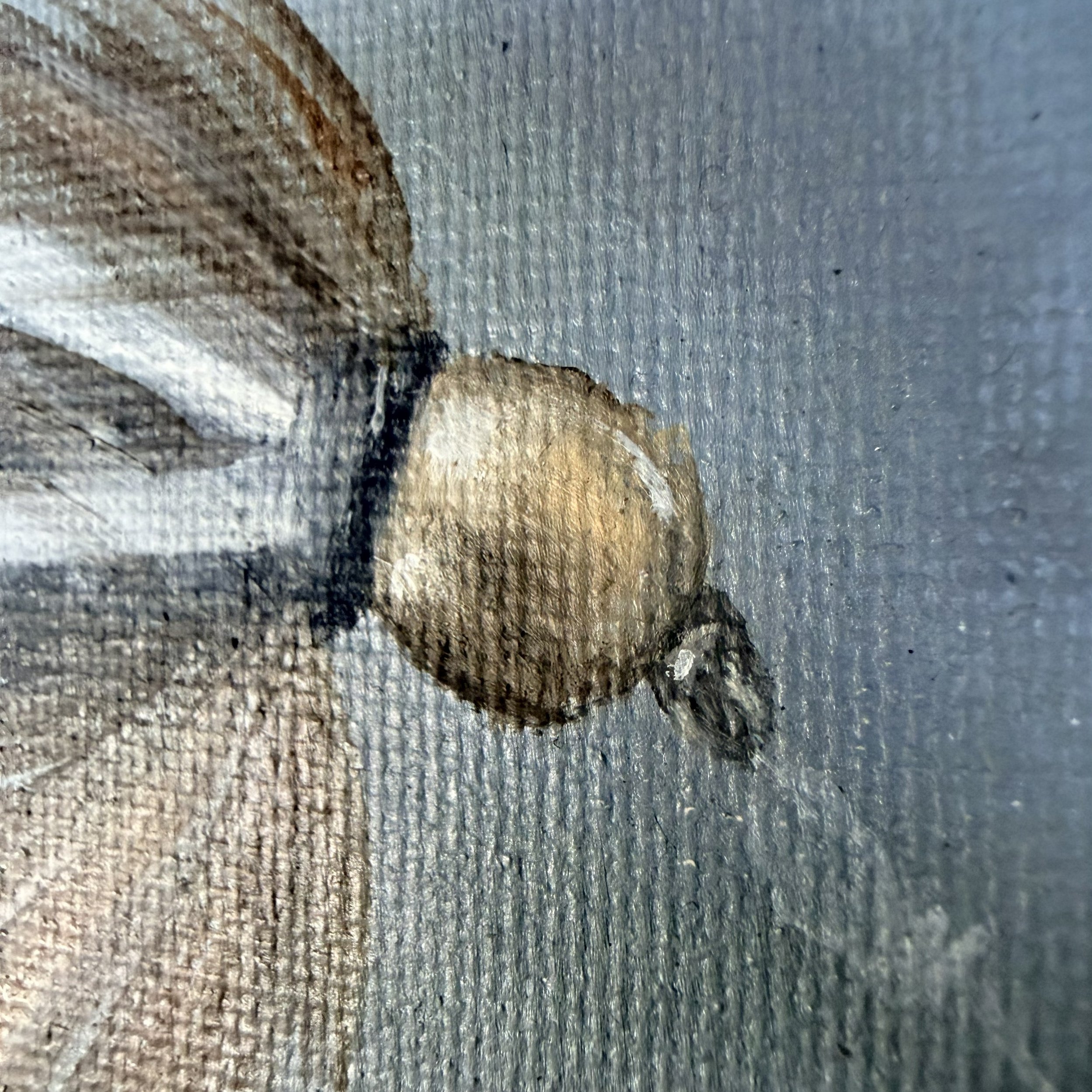 Close-up of a miniature fishing fly painted in oil with silvery white brushwork, olive-toned feather detail, subtle hook shape, and visible canvas texture.