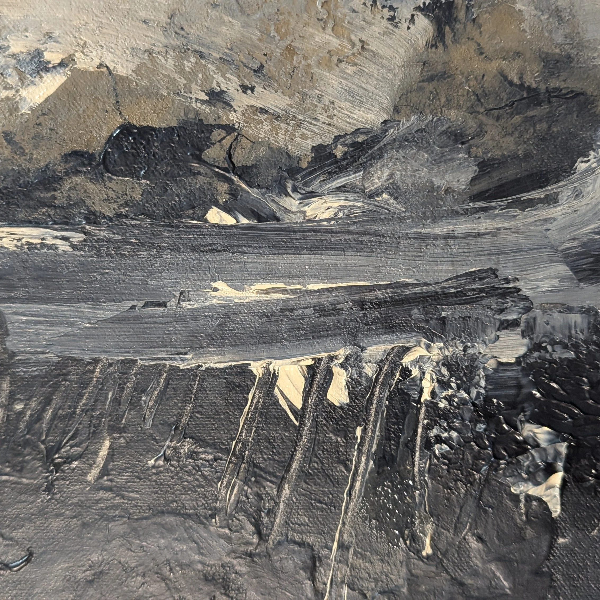 Close-up of textured acrylic paint with layered charcoal, gray, sand, and warm white marks across a weathered abstract surface.