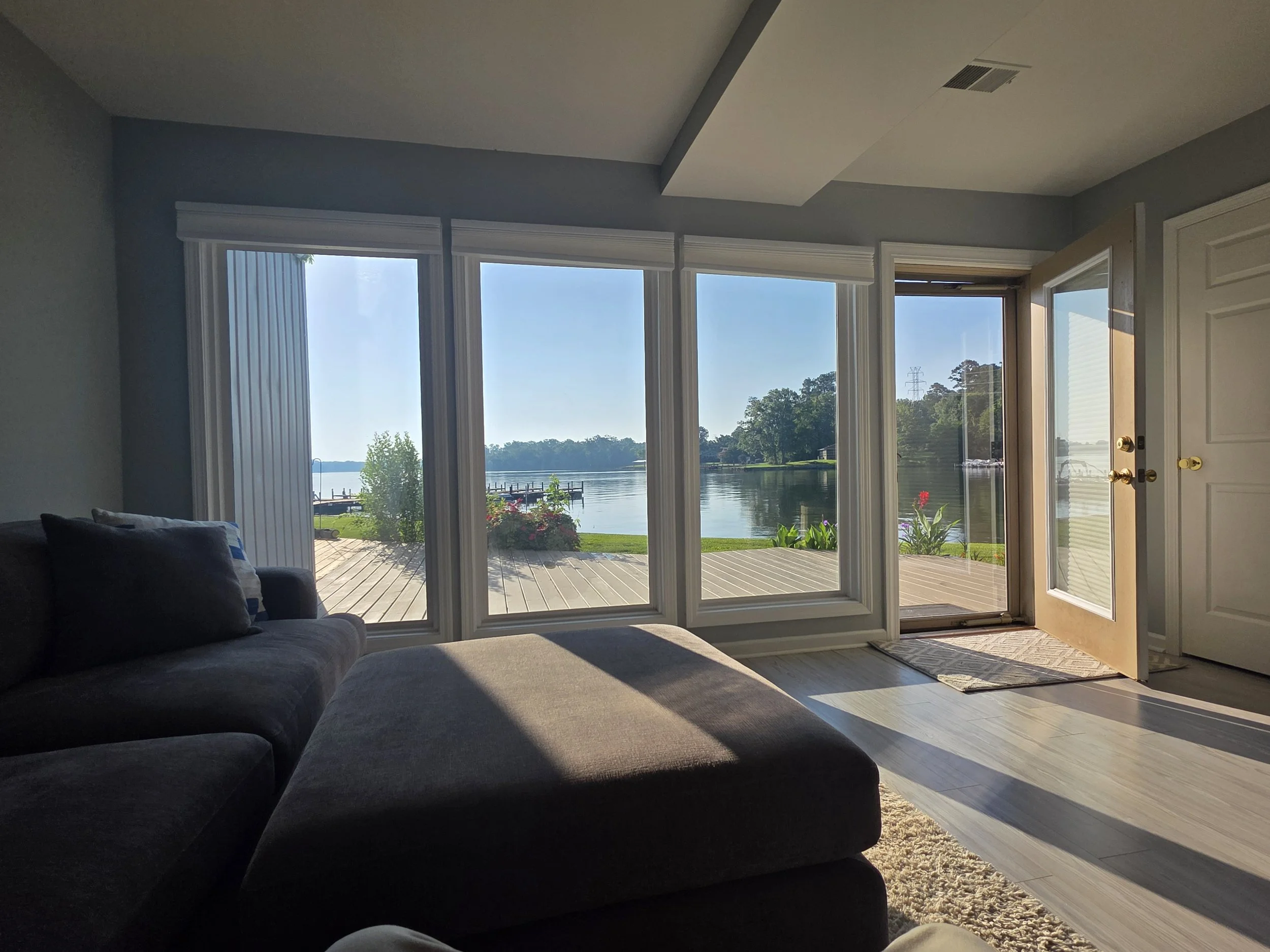 Living room with large windows overlooking Lake Greenwood and the private lakeside deck.