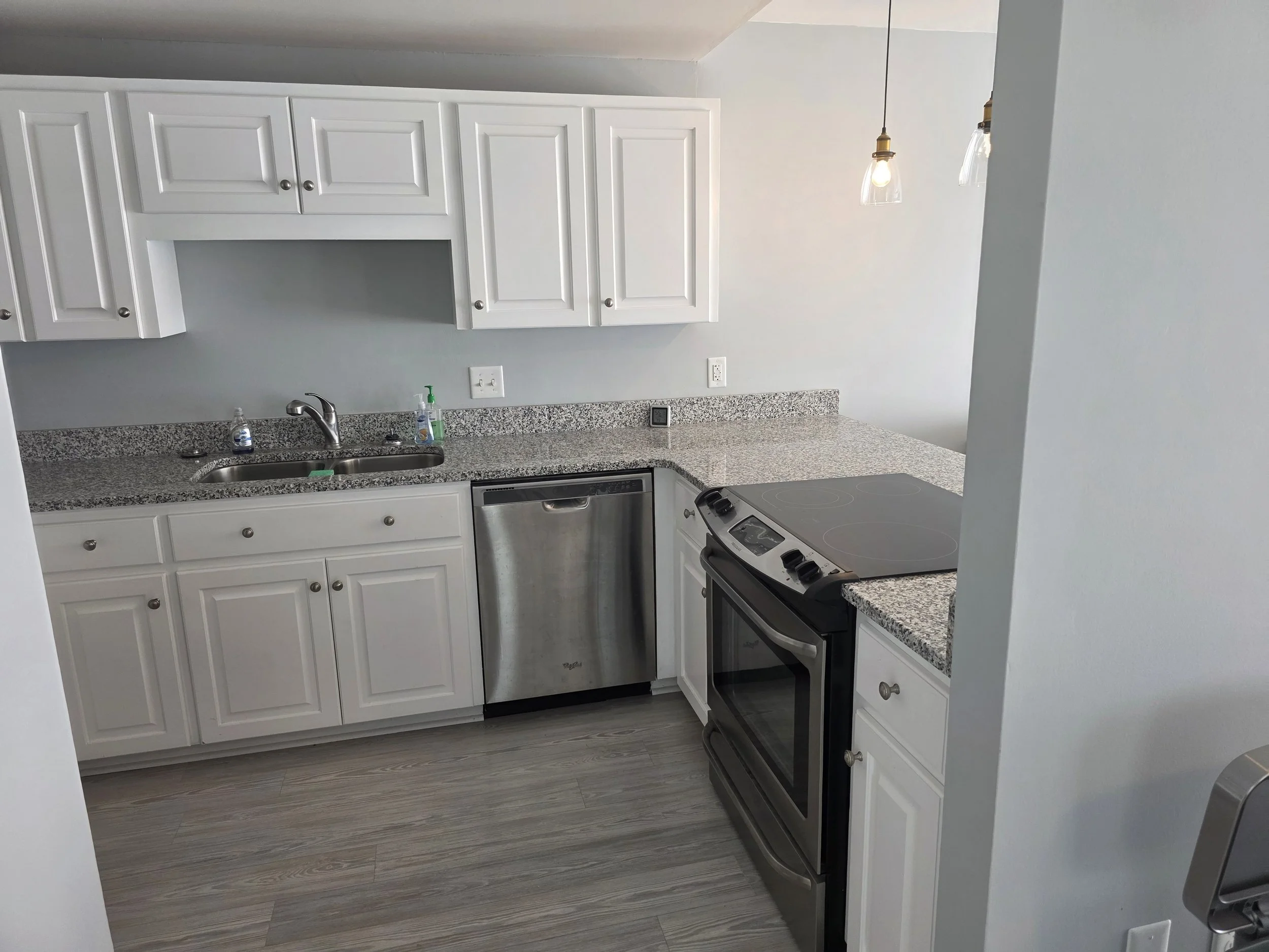 Kitchen with granite countertops, stainless steel appliances, and white cabinetry in a Lake Greenwood townhouse.