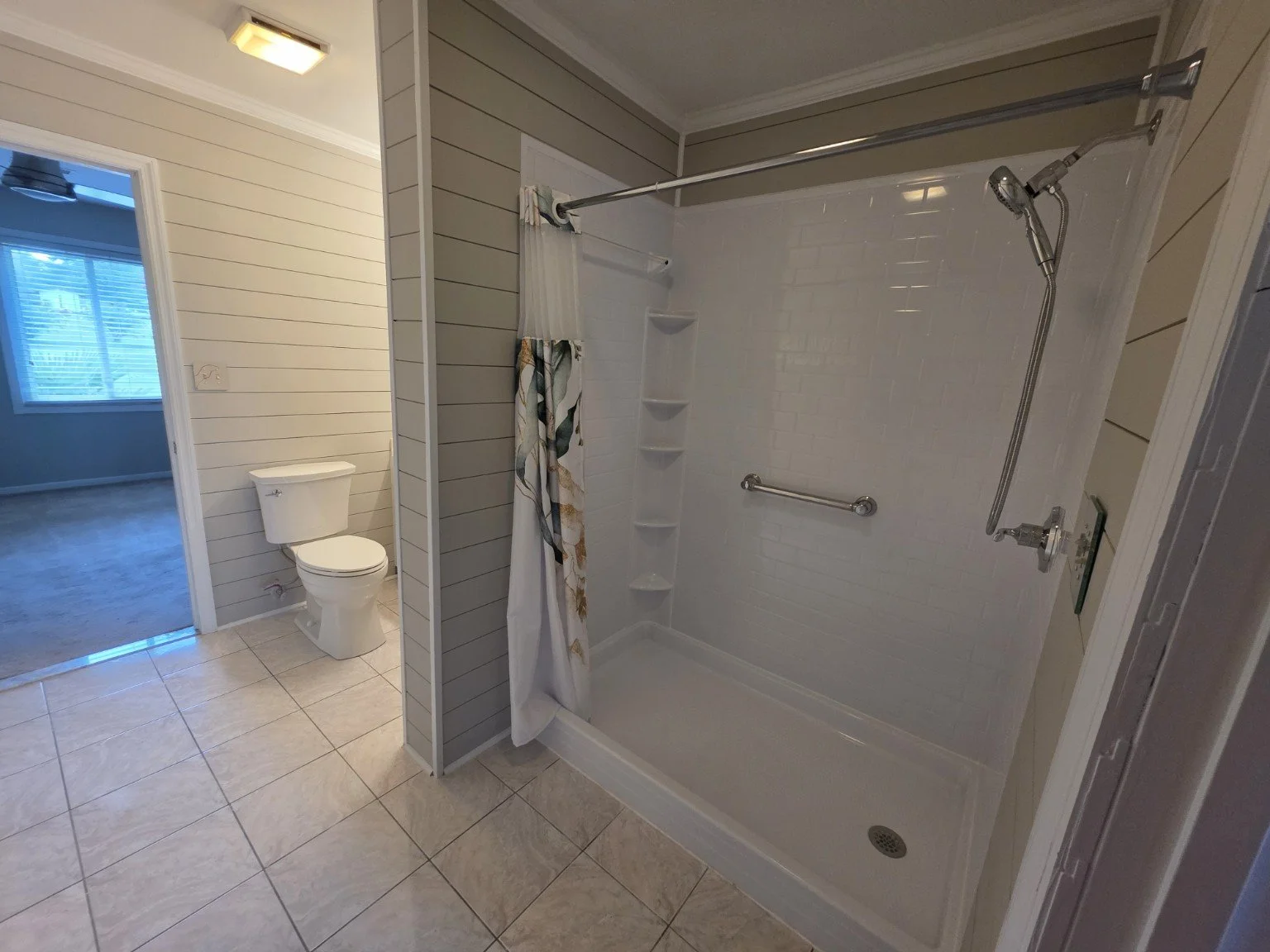 Remodeled bathroom with walk-in shower and shiplap-style wall detailing
