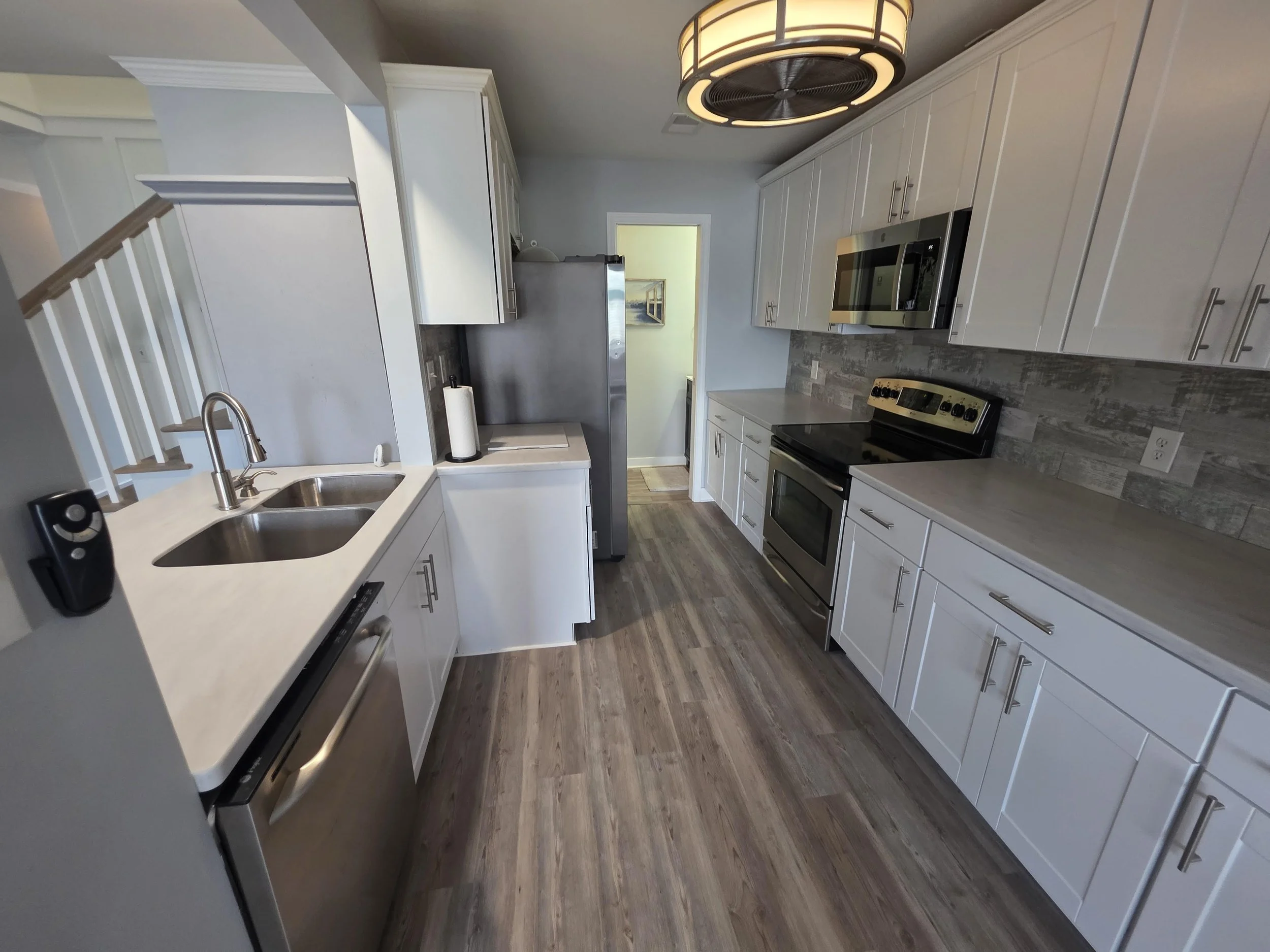 Updated kitchen with white cabinetry, solid-surface countertops and stainless steel appliances at 112 Lake Ridge Drive