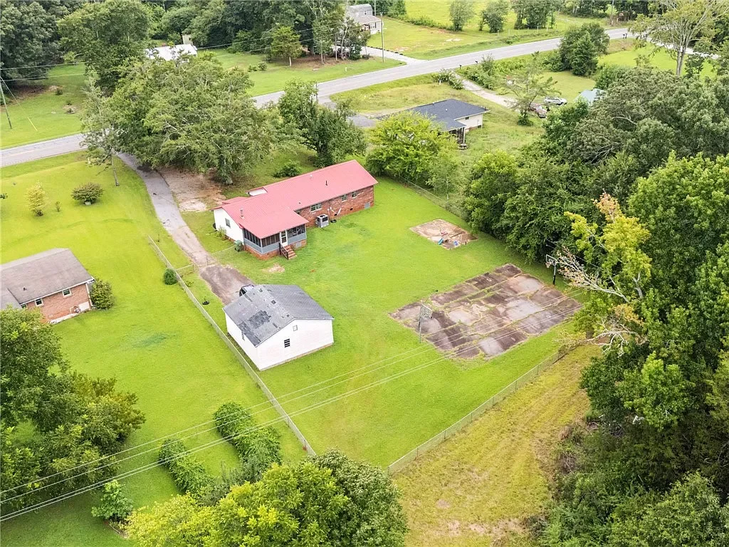 Aerial view of a three-bedroom brick rental home on 1.5 acres at 2740 Torrington Road in Laurens, SC, featuring a detached garage and spacious yard.