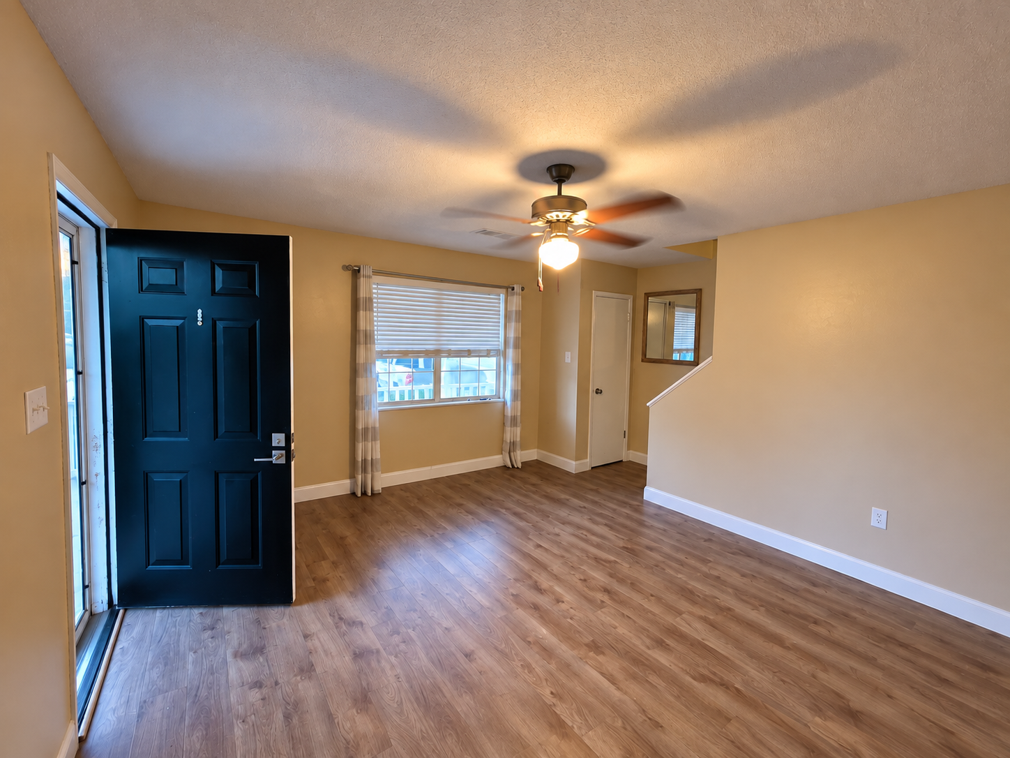 Living room with LVP flooring, front entrance, and staircase at 107 Country Village Ct in Greenwood, SC