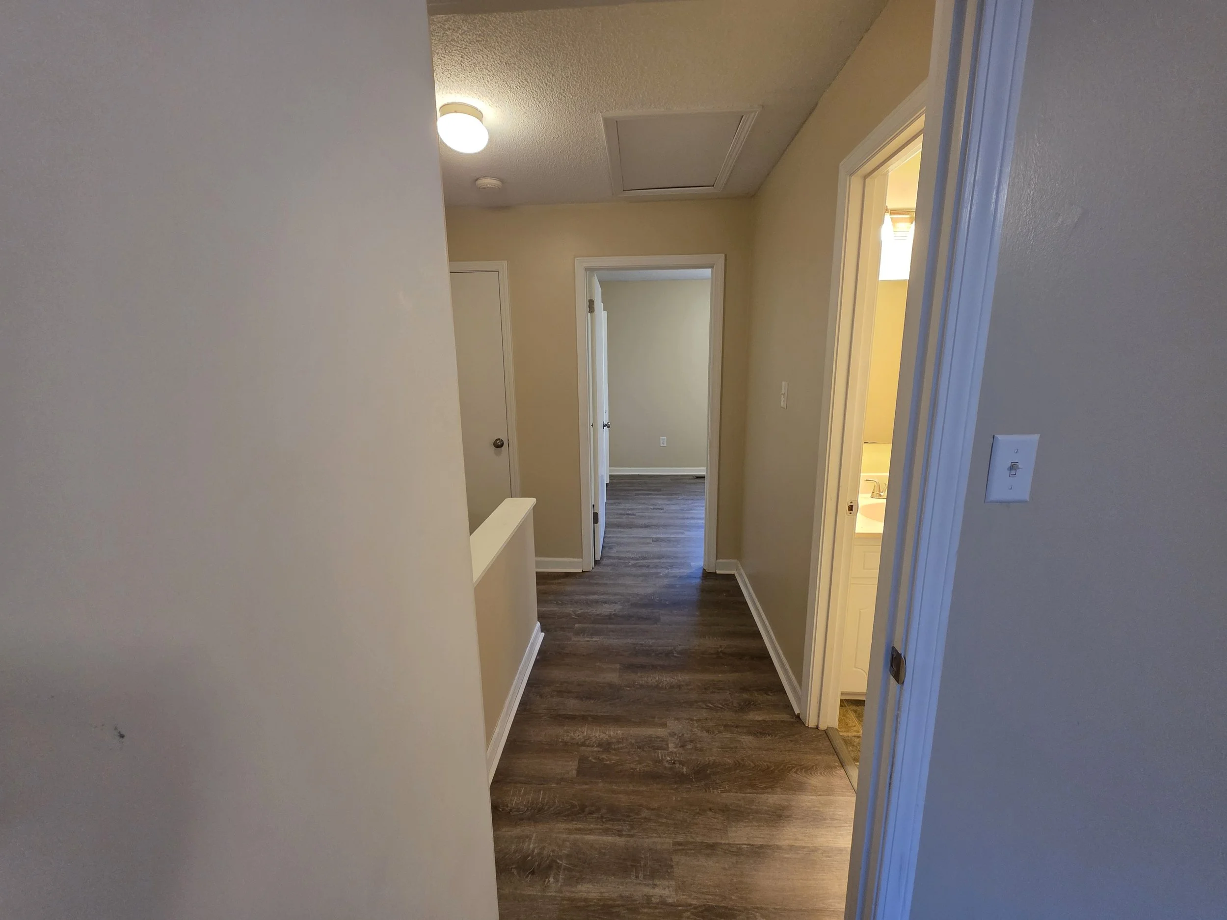 Upstairs hallway with new LVP flooring connecting the bedrooms and bathroom at 107 Country Village Ct