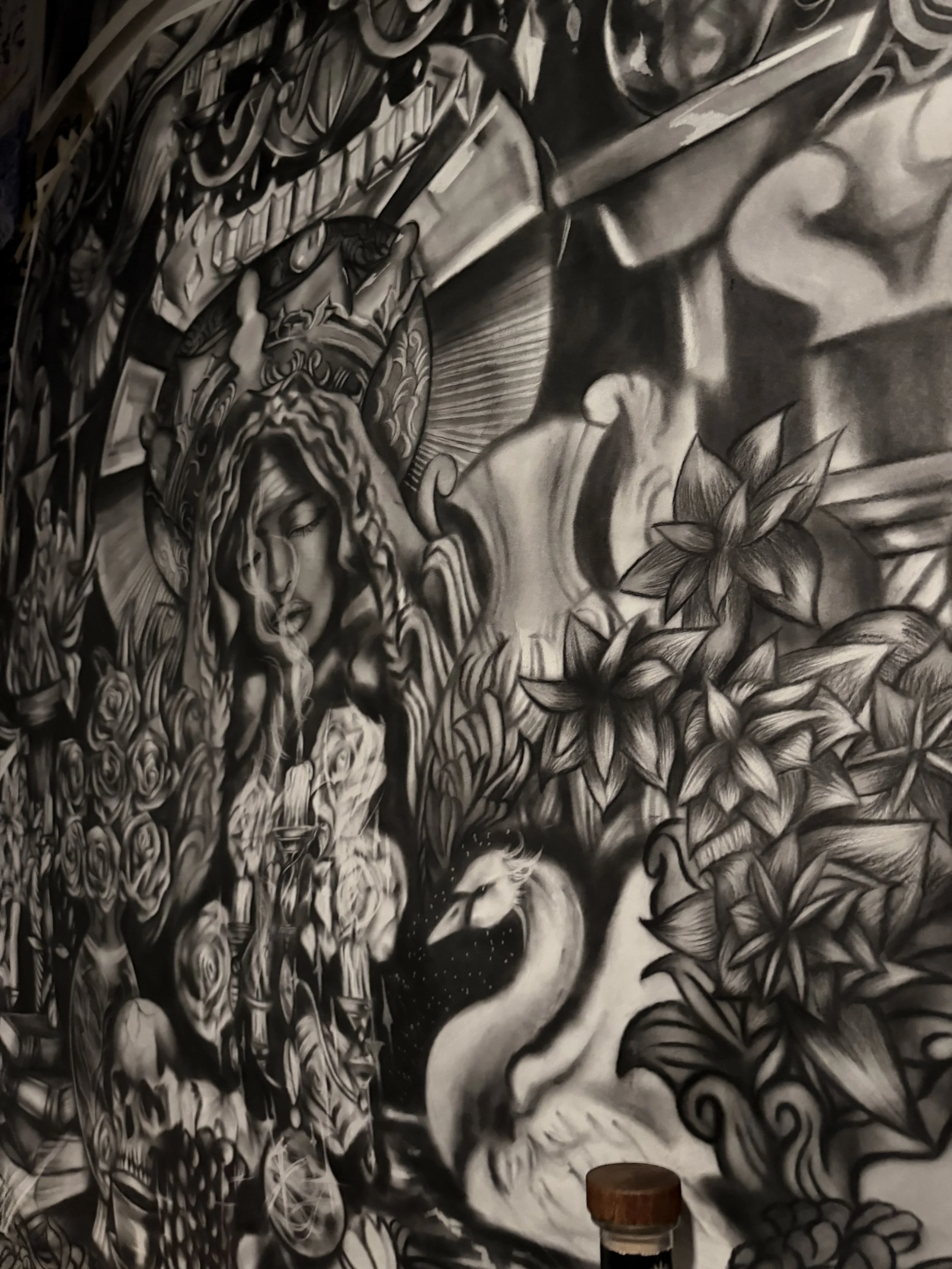 Black and white tattoo artwork of a woman with flowing hair, surrounded by flowers and intricate patterns.