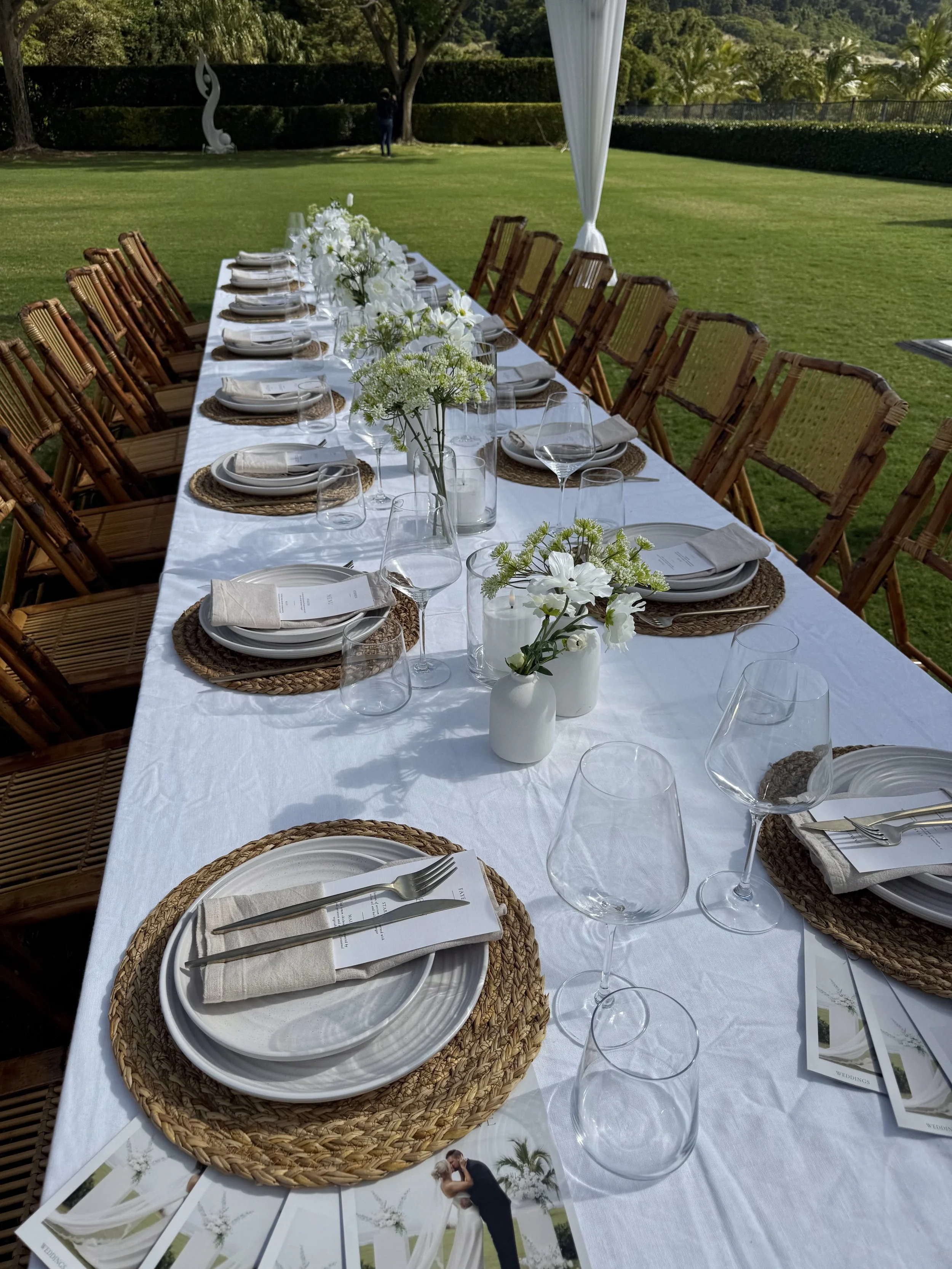 Luxury wedding tablescape styling with bamboo chairs, layered place settings, linen, florals and reception styling in Airlie Beach, Whitsundays by Salt & Silk Collective.