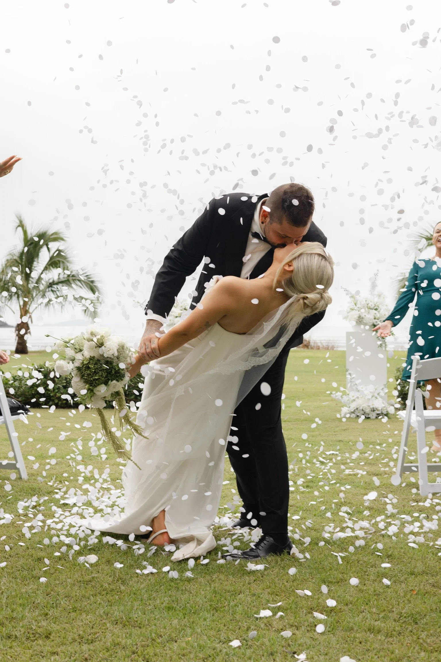Bride and groom celebrating their romantic Whitsunday wedding ceremony with coastal views, elegant white floral styling and luxury wedding design by Salt & Silk Collective in Airlie Beach.