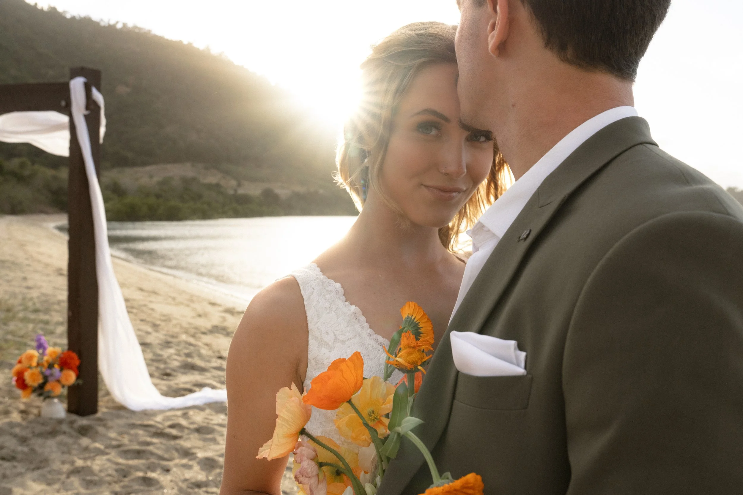 Bride and groom during their intimate Airlie Beach elopement ceremony overlooking the Whitsunday coastline, featuring romantic coastal wedding styling by Salt & Silk Collective.