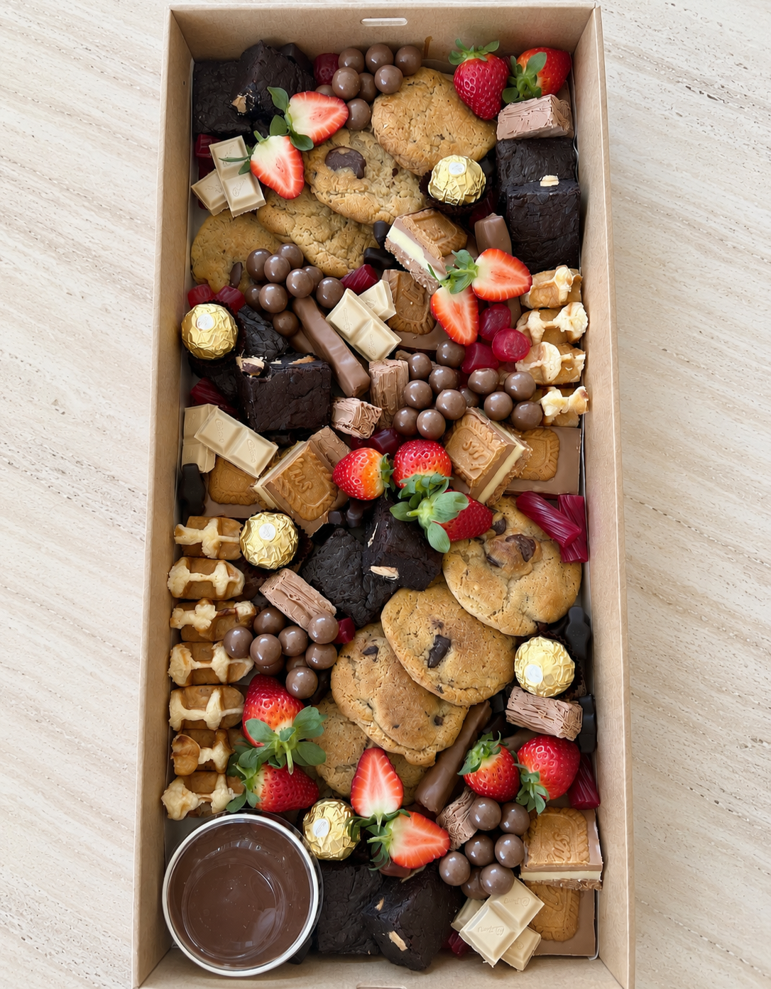Sweet grazing box with chocolates, cookies, brownies and fresh strawberries by Salt & Silk Collective, offering dessert platters, grazing boxes and event catering in Airlie Beach and the Whitsundays.