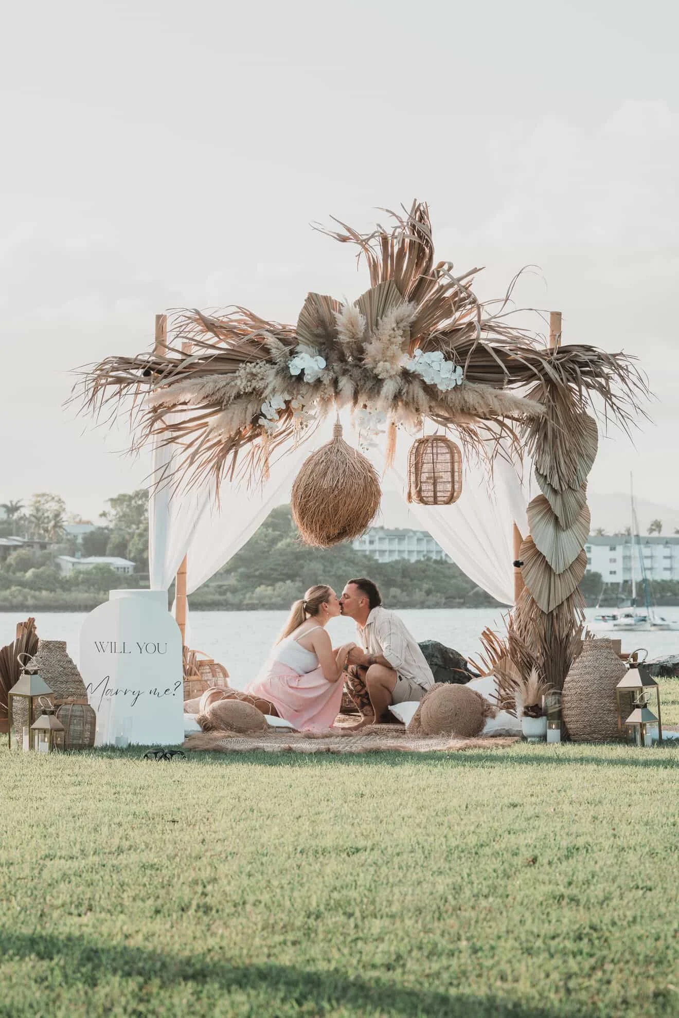Boho luxury proposal picnic setup in Airlie Beach and the Whitsundays featuring coastal styling, florals, candles, grazing and a romantic engagement experience by Salt & Silk Collective