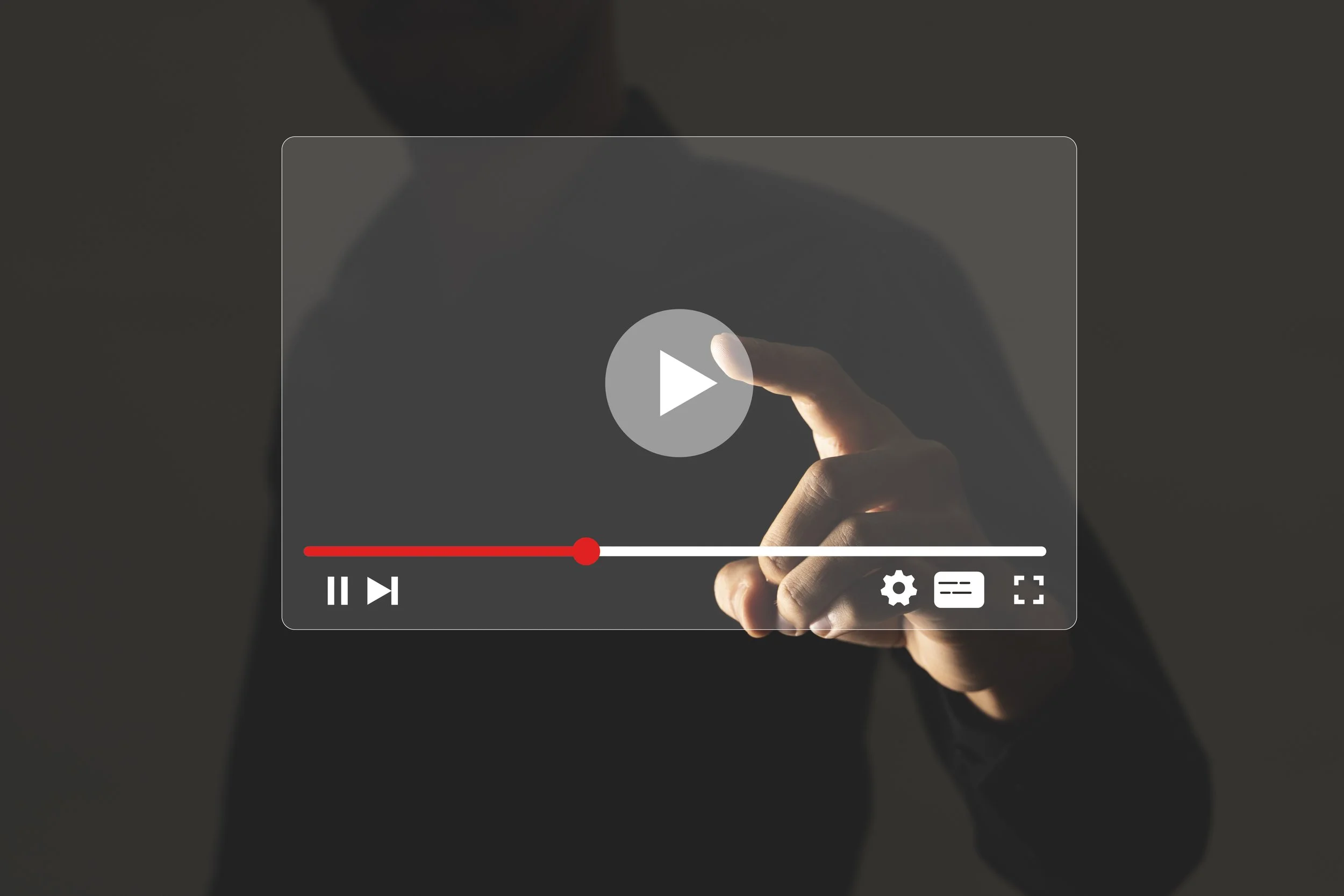 Person holding a smartphone with a video playback interface visible on the screen.