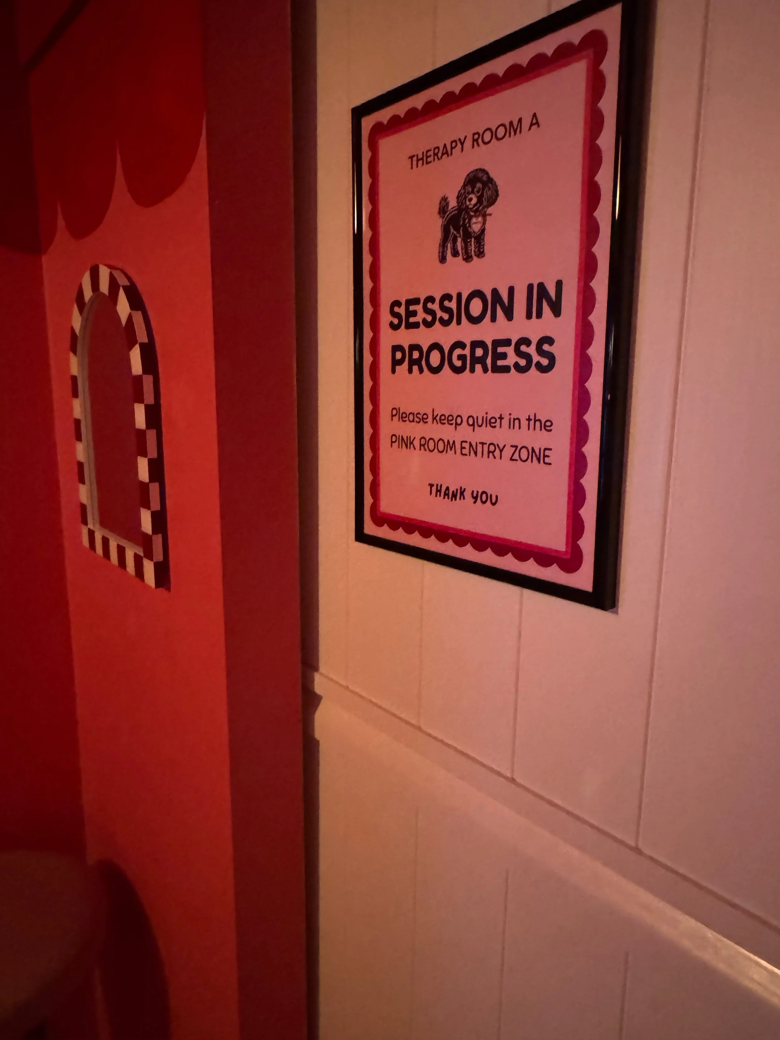 Sign on a door indicating a therapy room in progress with a cartoon dog illustration.