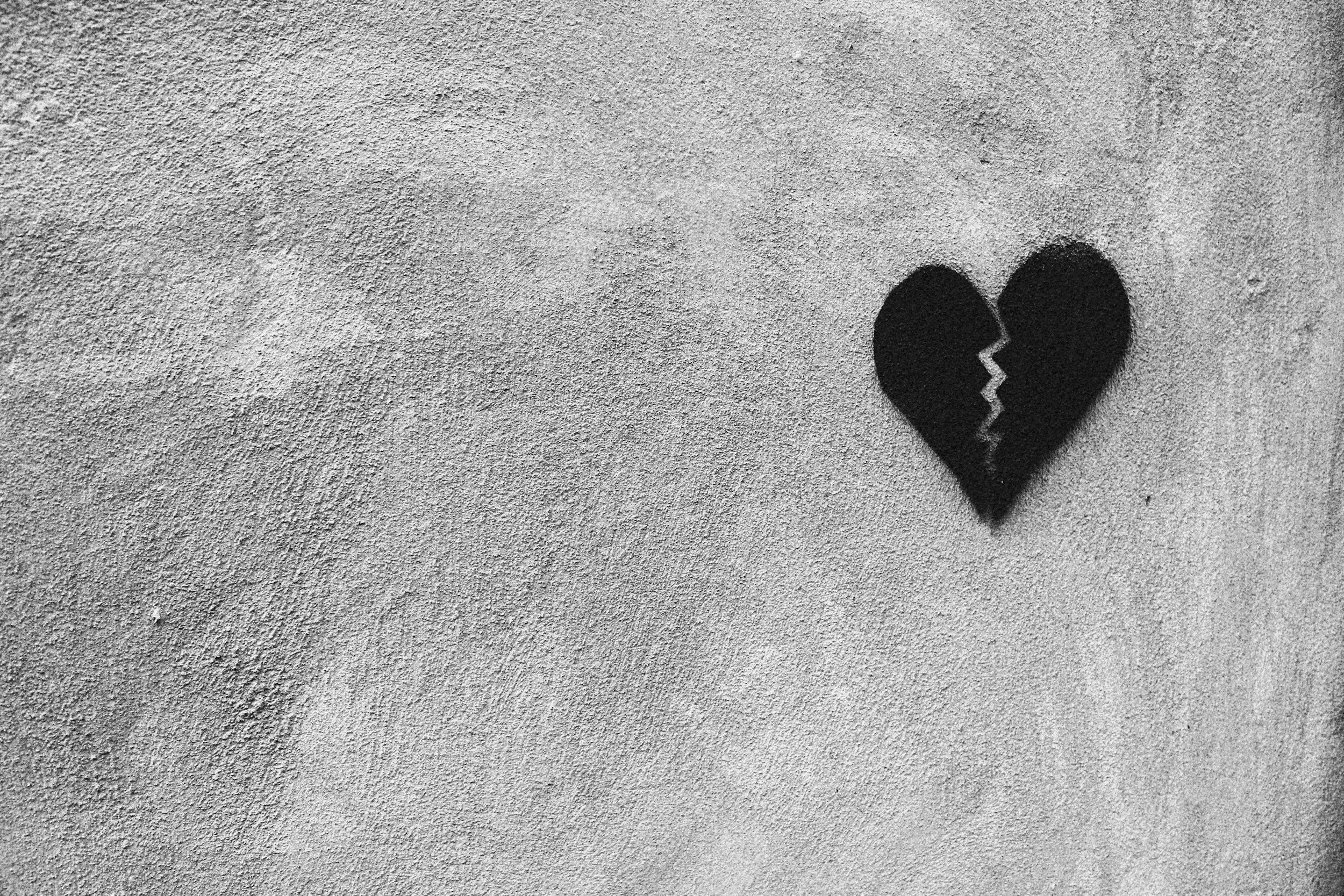 A graphic of a broken heart on a textured wall, symbolizing the pain of betrayal and the path toward relational healing.