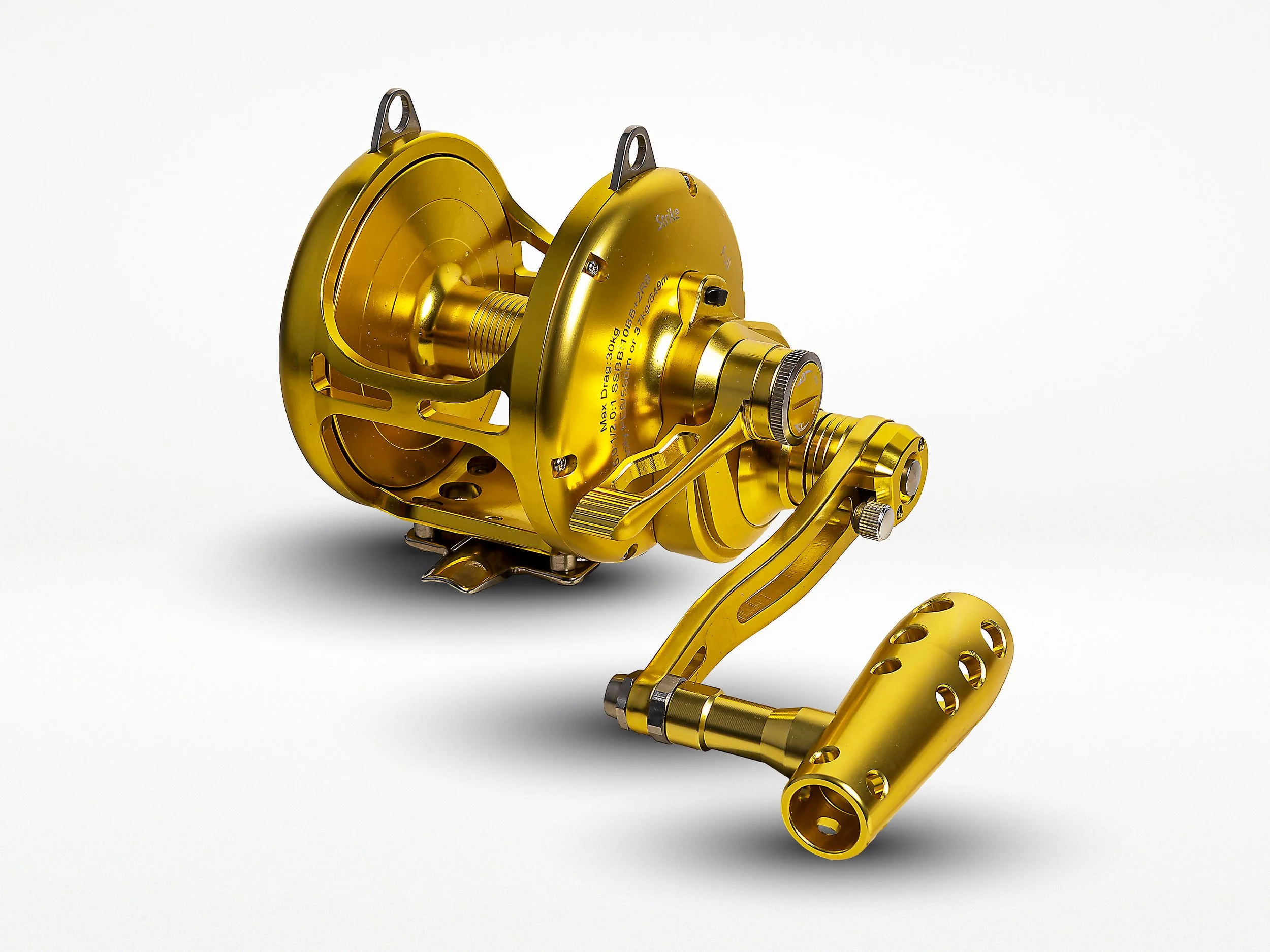 Close-up of a gold fishing reel with a white background.