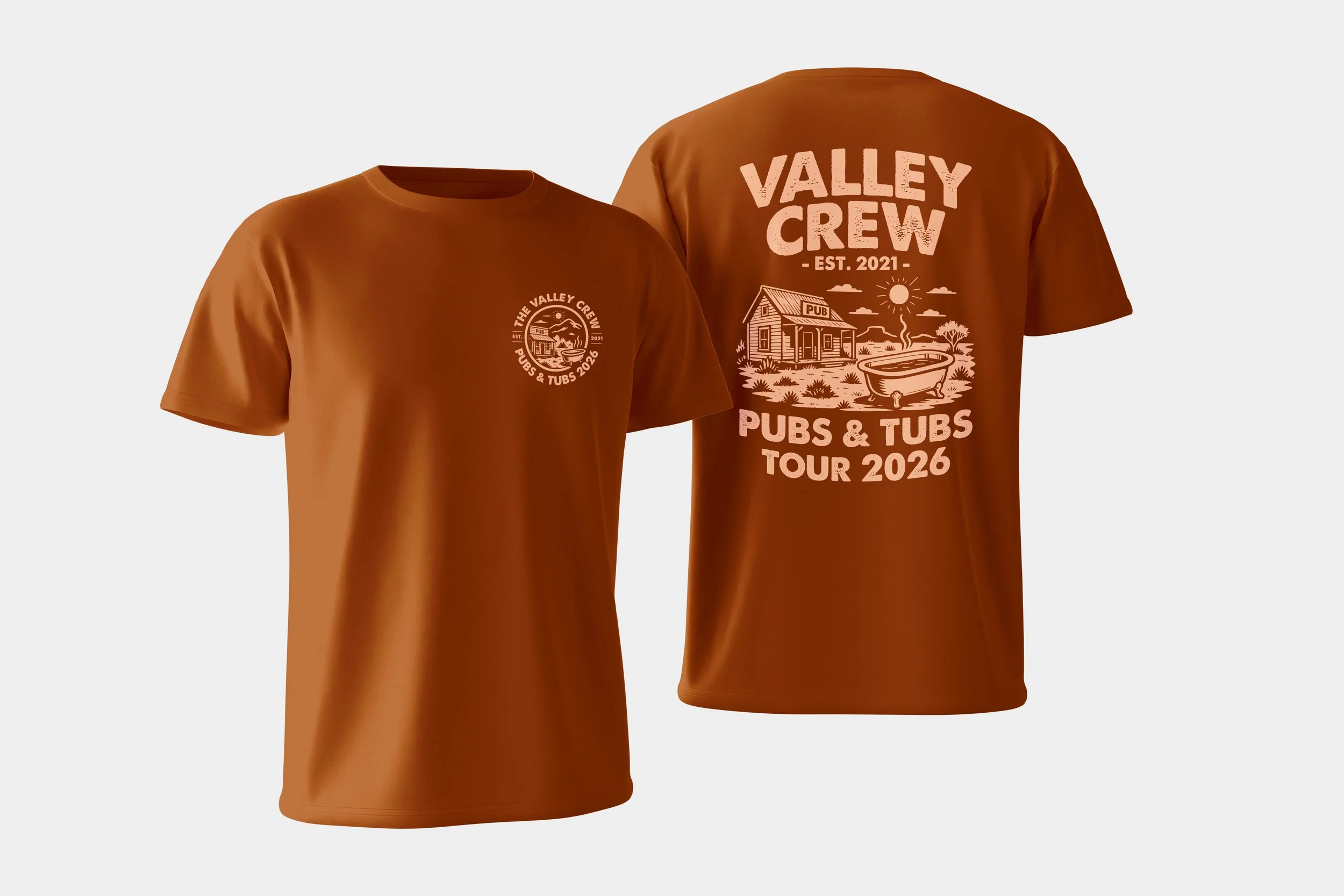 Brown T-shirts with graphic designs for Valley Creek Pubs & Tubs Tour 2026, featuring a house, bathtub, and nature scene.