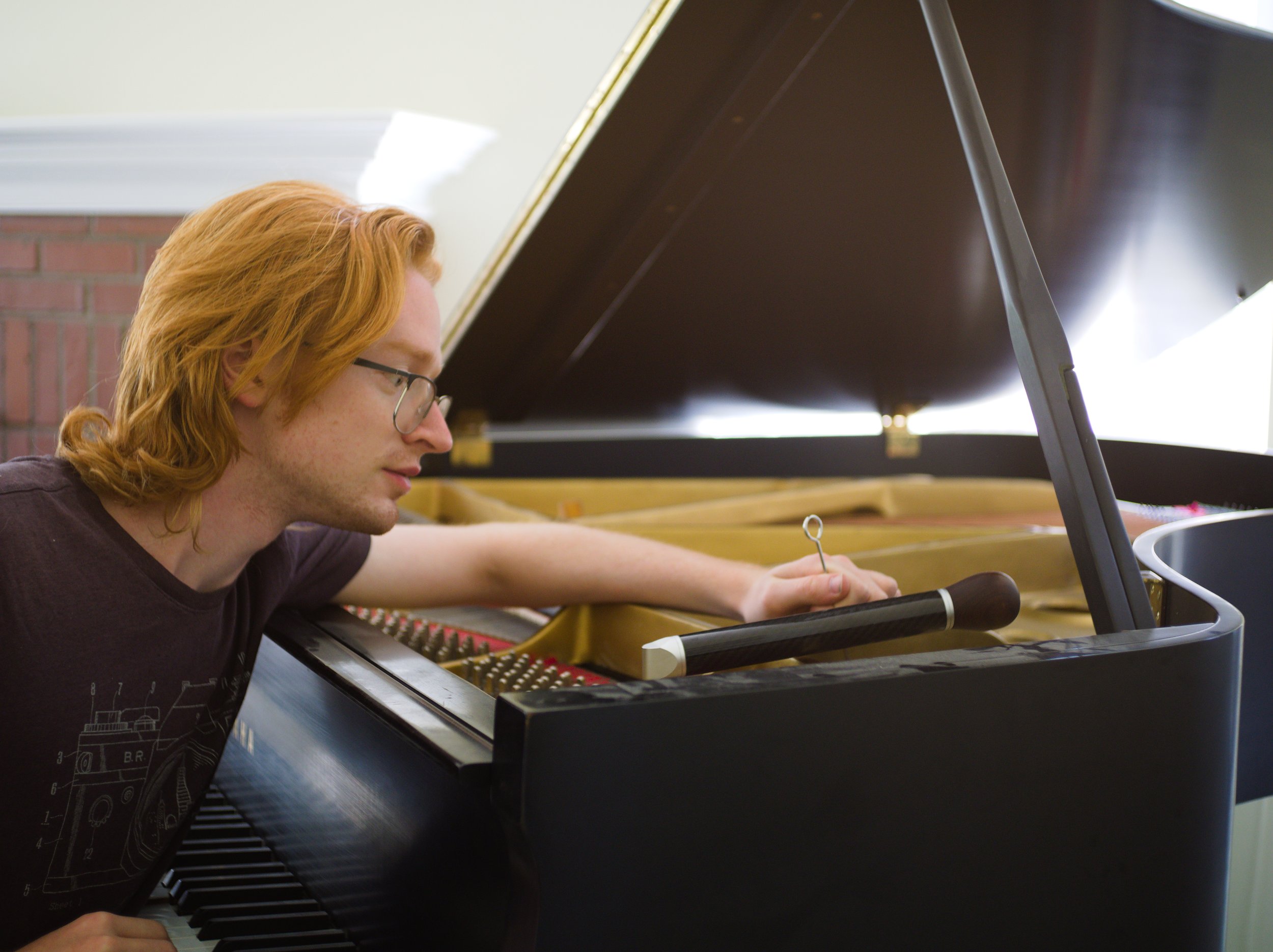Brendan Coller tuning a Yamaha grand piano