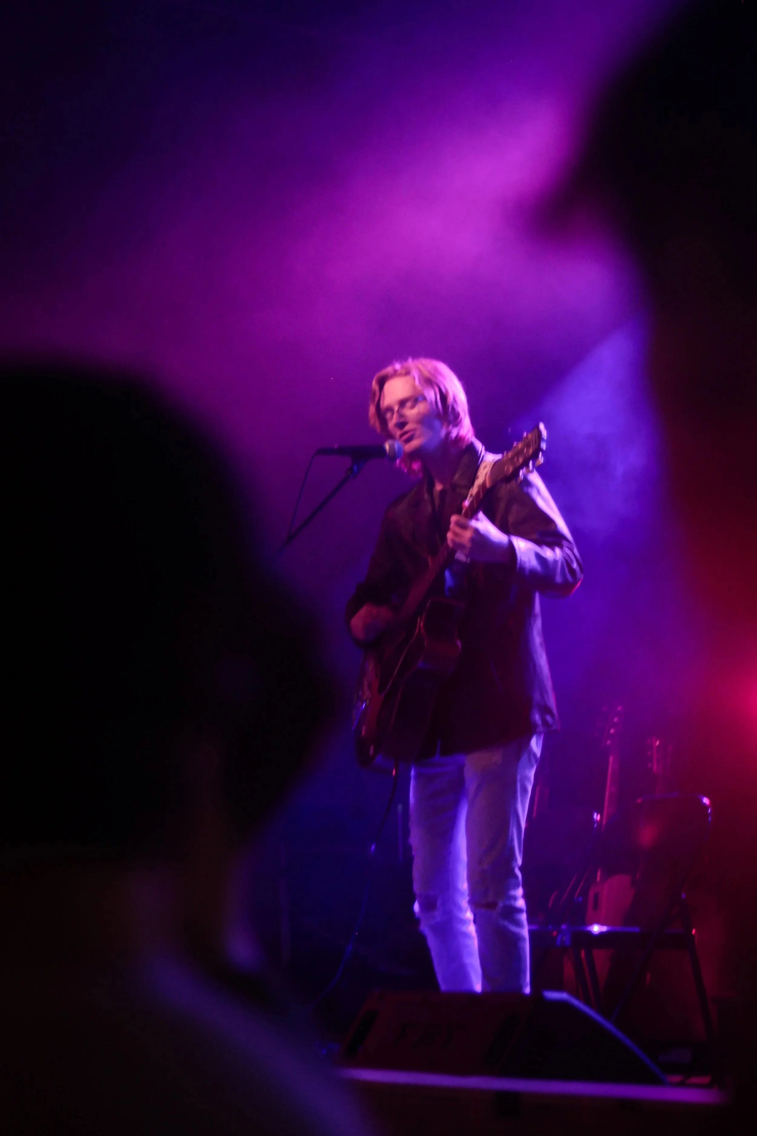 Brendan Coller singing and playing guitar on stage