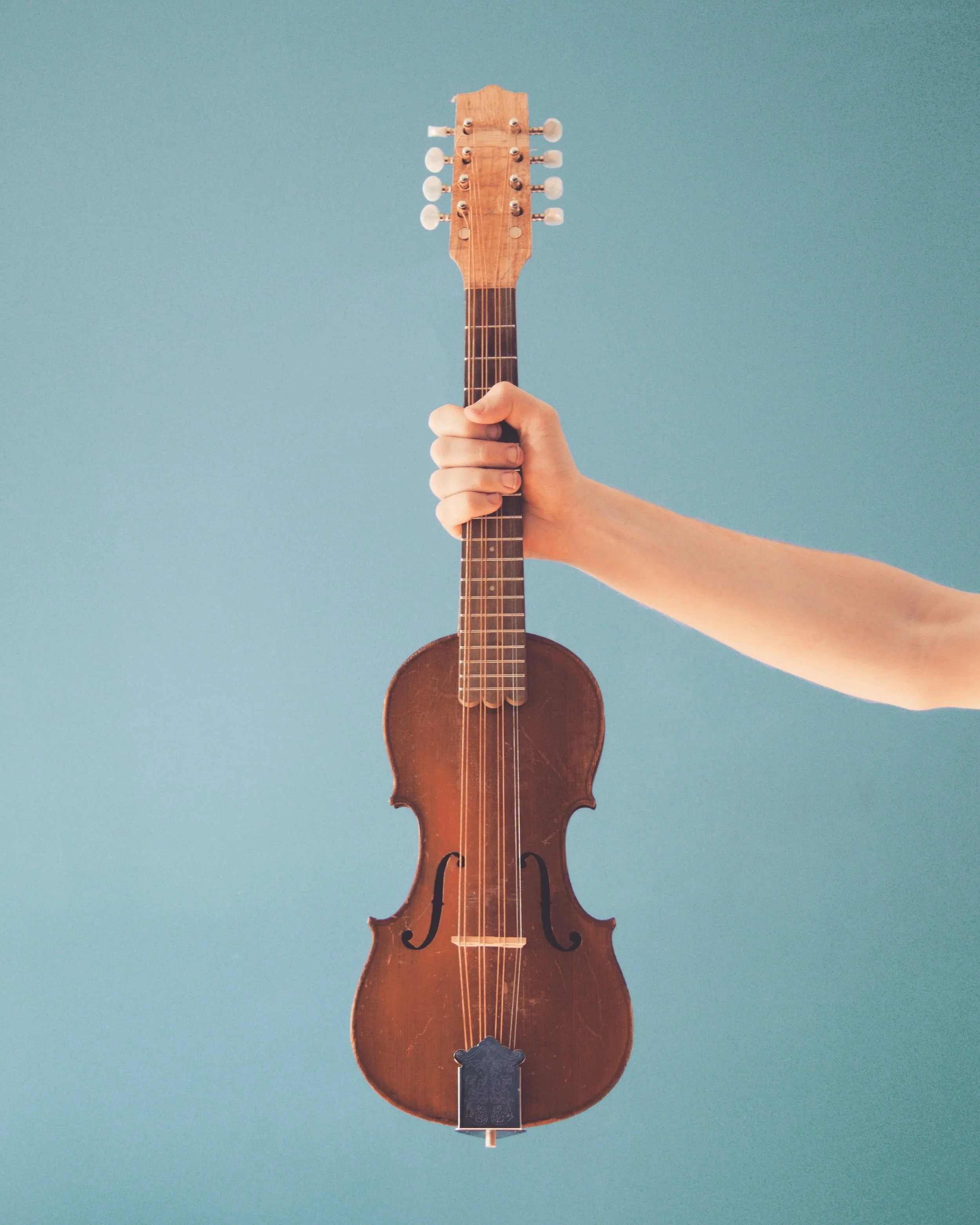 Brendan Coller holding a mandolin made from the body of a violin
