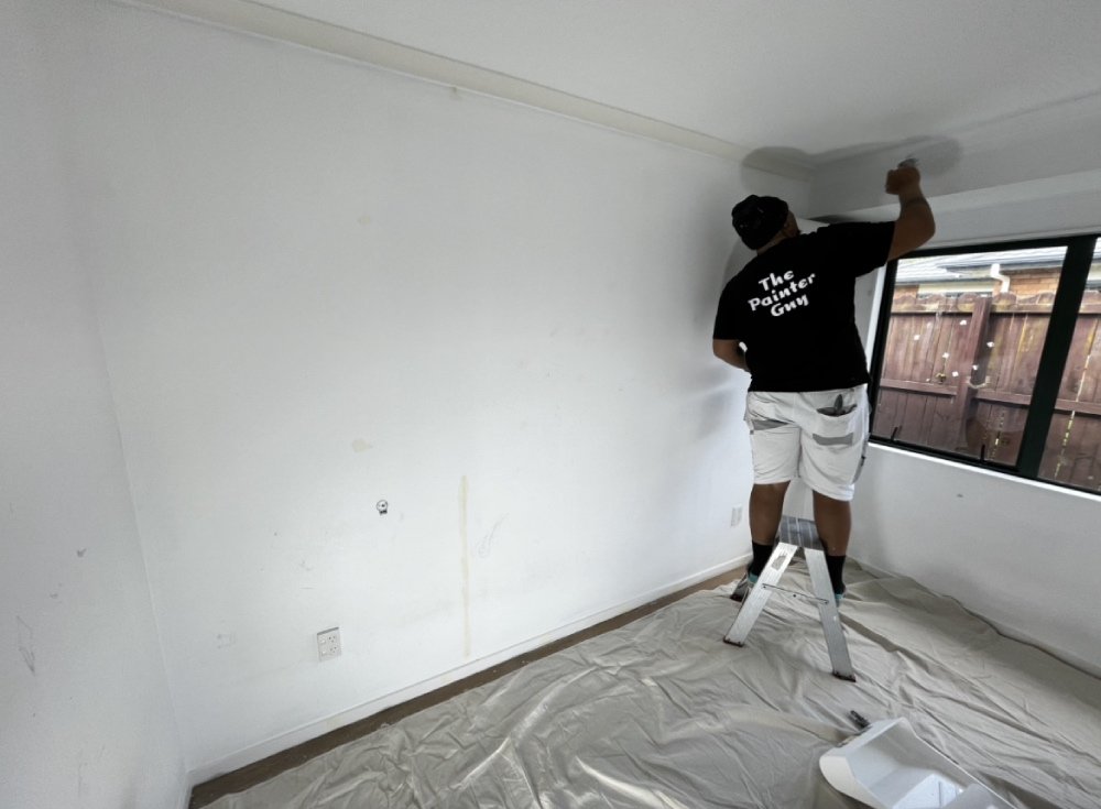 Painting Contractor Cutting In Ceiling With White Paint