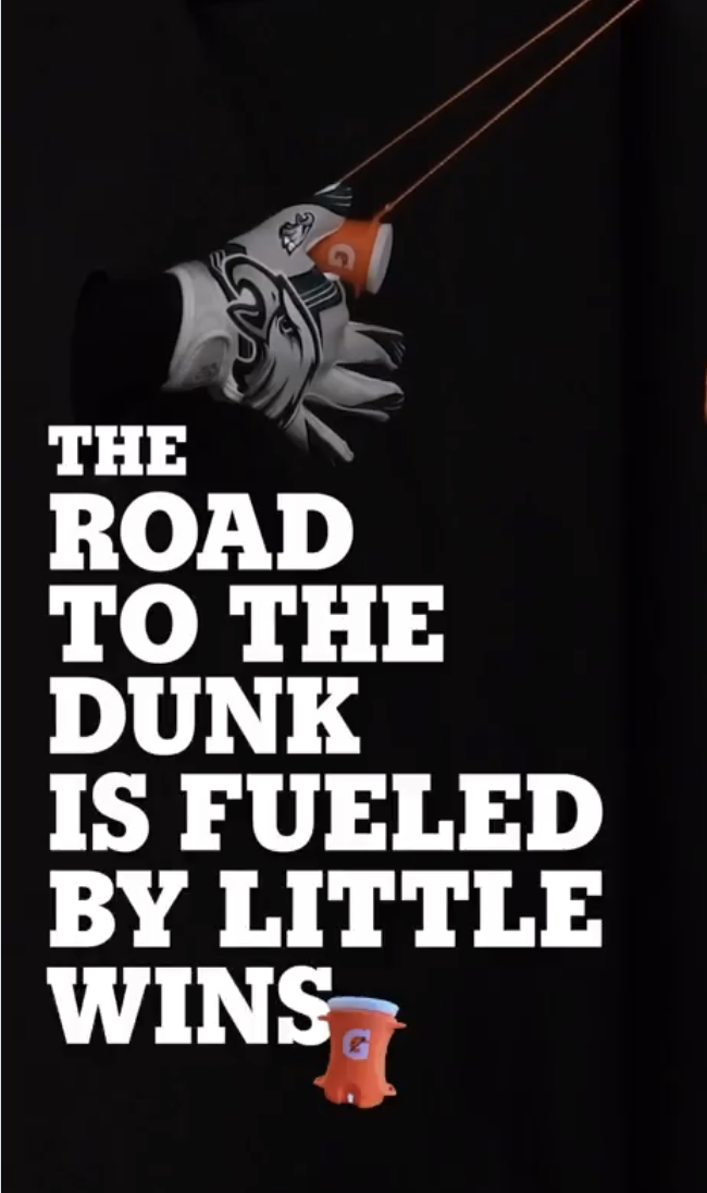 A close-up of a pair of Gatorade branded goalkeeper gloves, a small portable speaker, and a basketball hoop in the background. Text overlay reads "The road to the dunk is fueled by little wins."