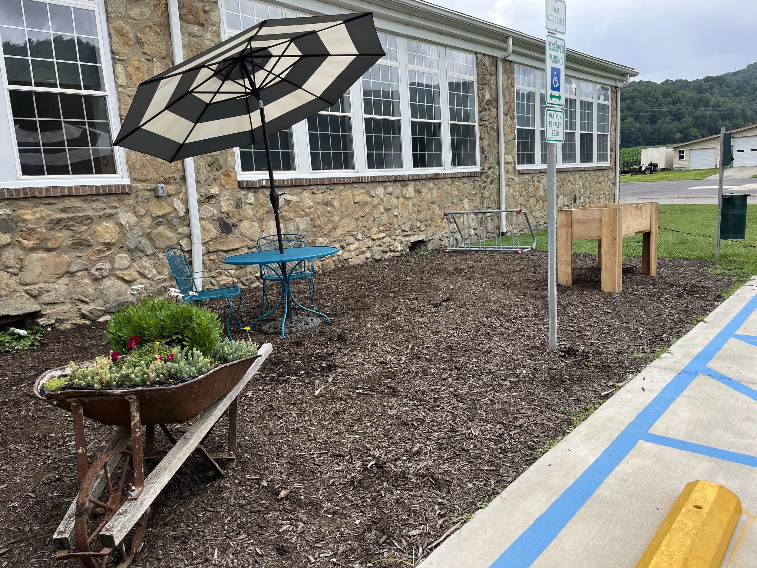 2026 - Addition of Outdoor Seating Area, elevated made and planted by 4-H, Wheelbarrow planter made from metal-wheeled wheelbarrow found in the SCCC and made into a planter/maintained by a volunteer.