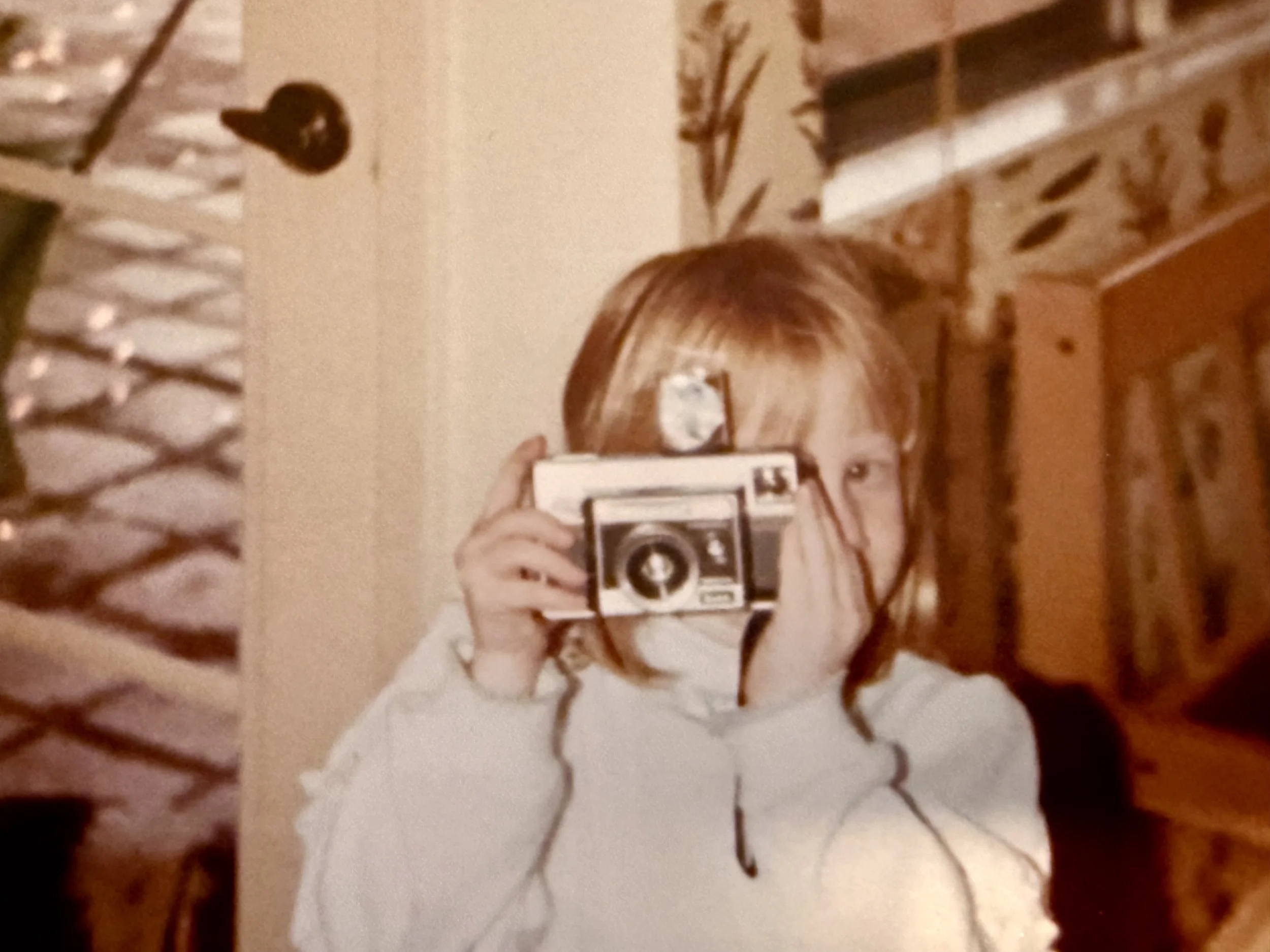 child holding vintage camera