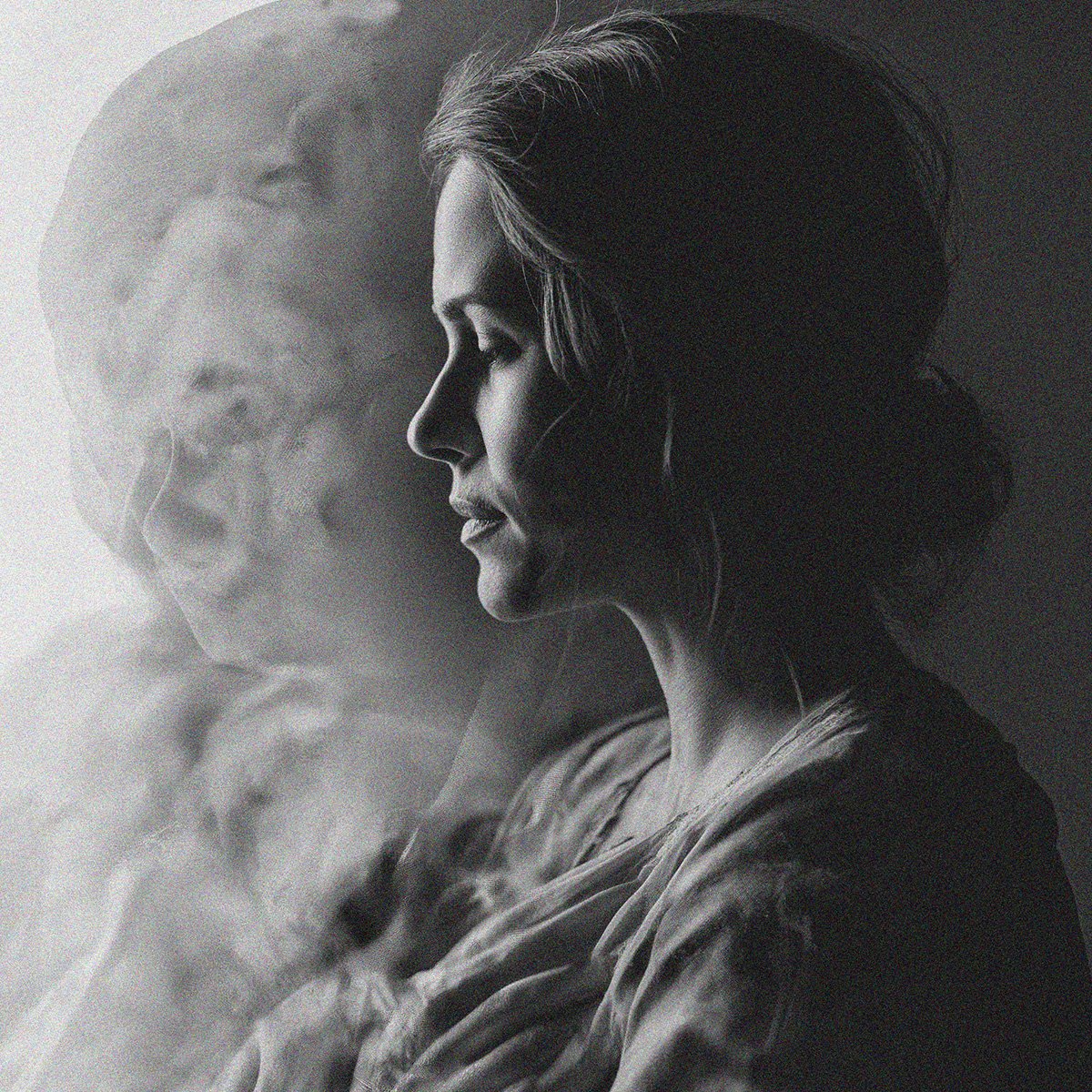 Black and white side profile of a woman with her eyes closed, overlaid with a faint image of a man's face.