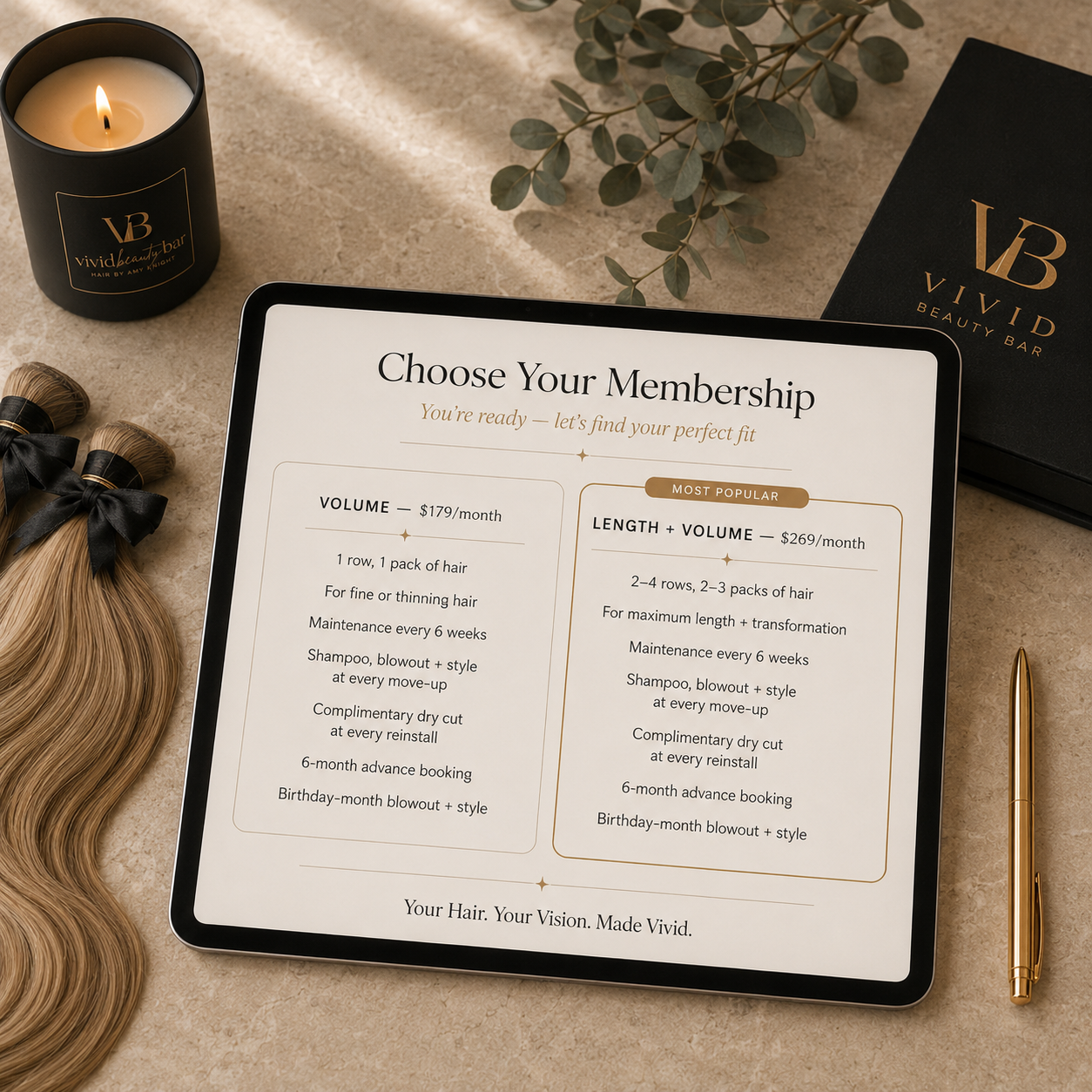 Tablet displaying the membership options for a beauty bar, with a candle, hair extensions, a pen, and a black box labeled Vivid Beauty Bar on a beige surface.