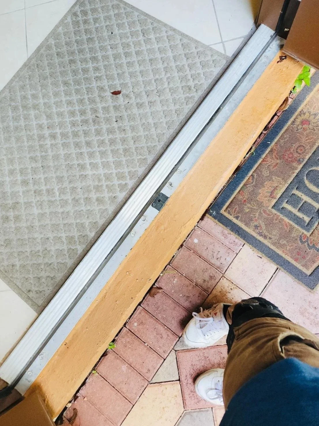 The bottom of a door with a missing or disconnected threshold, revealing a gap between the door frame and the floor was renovated by sian home services.