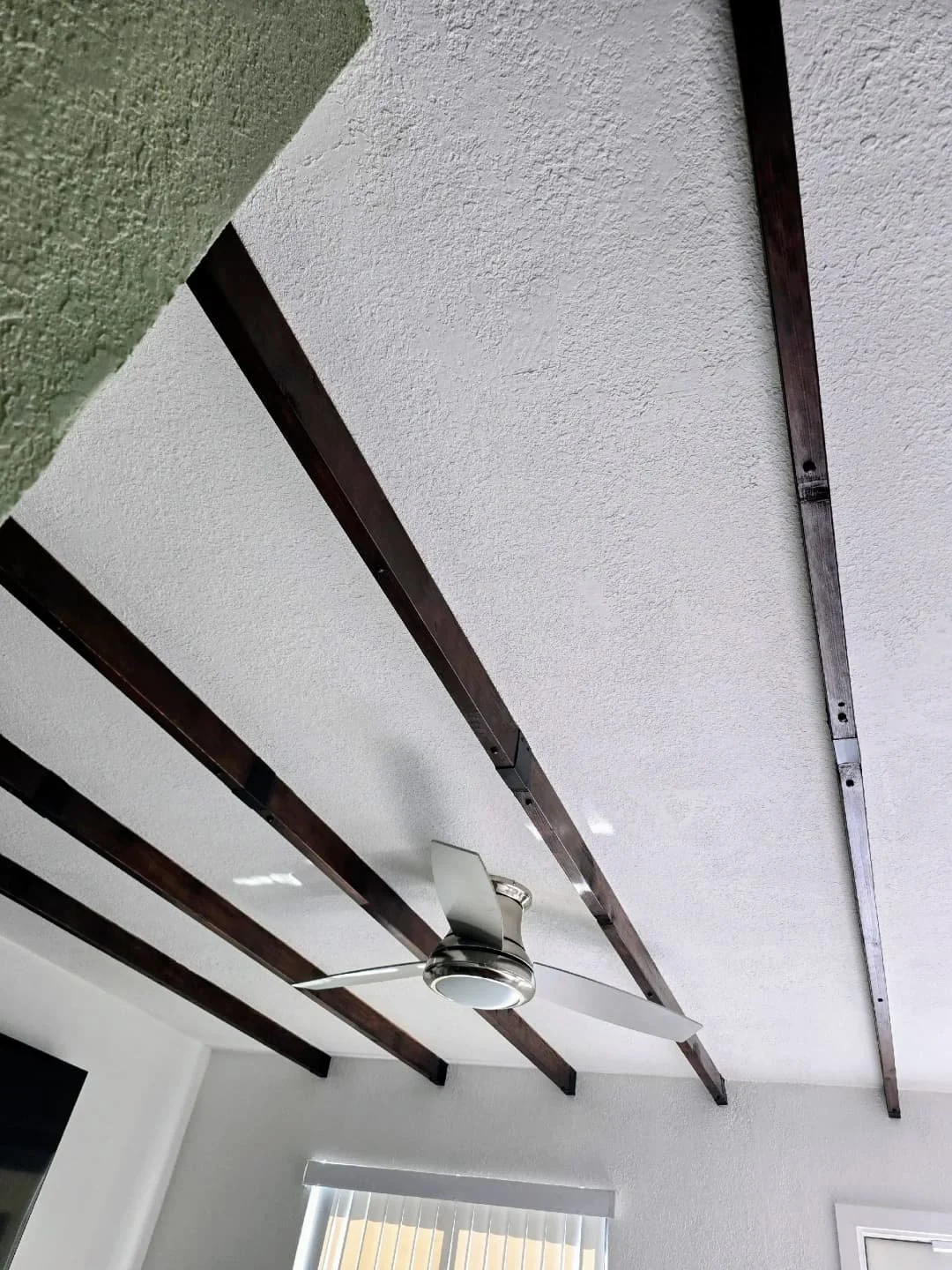 Ceiling with dark brown wooden beams, faux beam  installed by sian home services