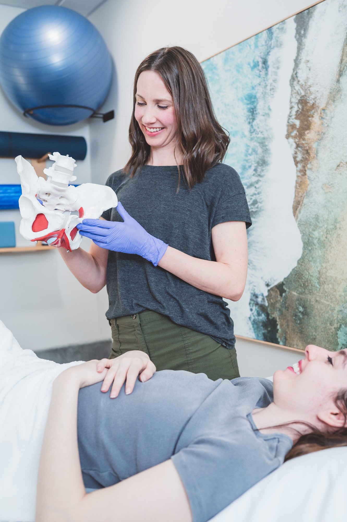 pelvic therapist using a model to demonstrate pelvic muscles