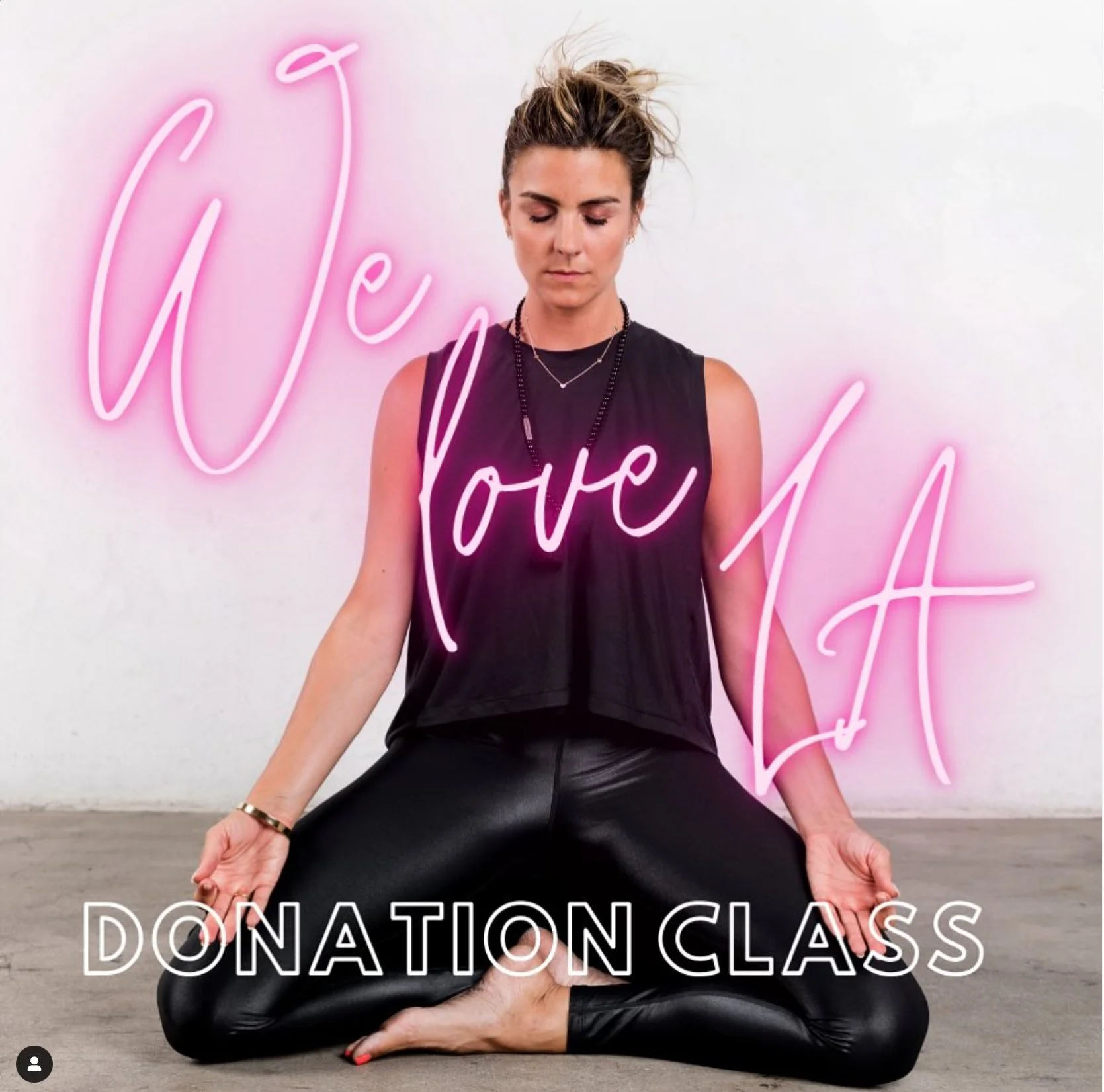 Nicole Sciacca of Sweat + Stillness practicing yoga in front of a neon sign that reads 'We Love LA' and 'Donation Class' at the bottom.