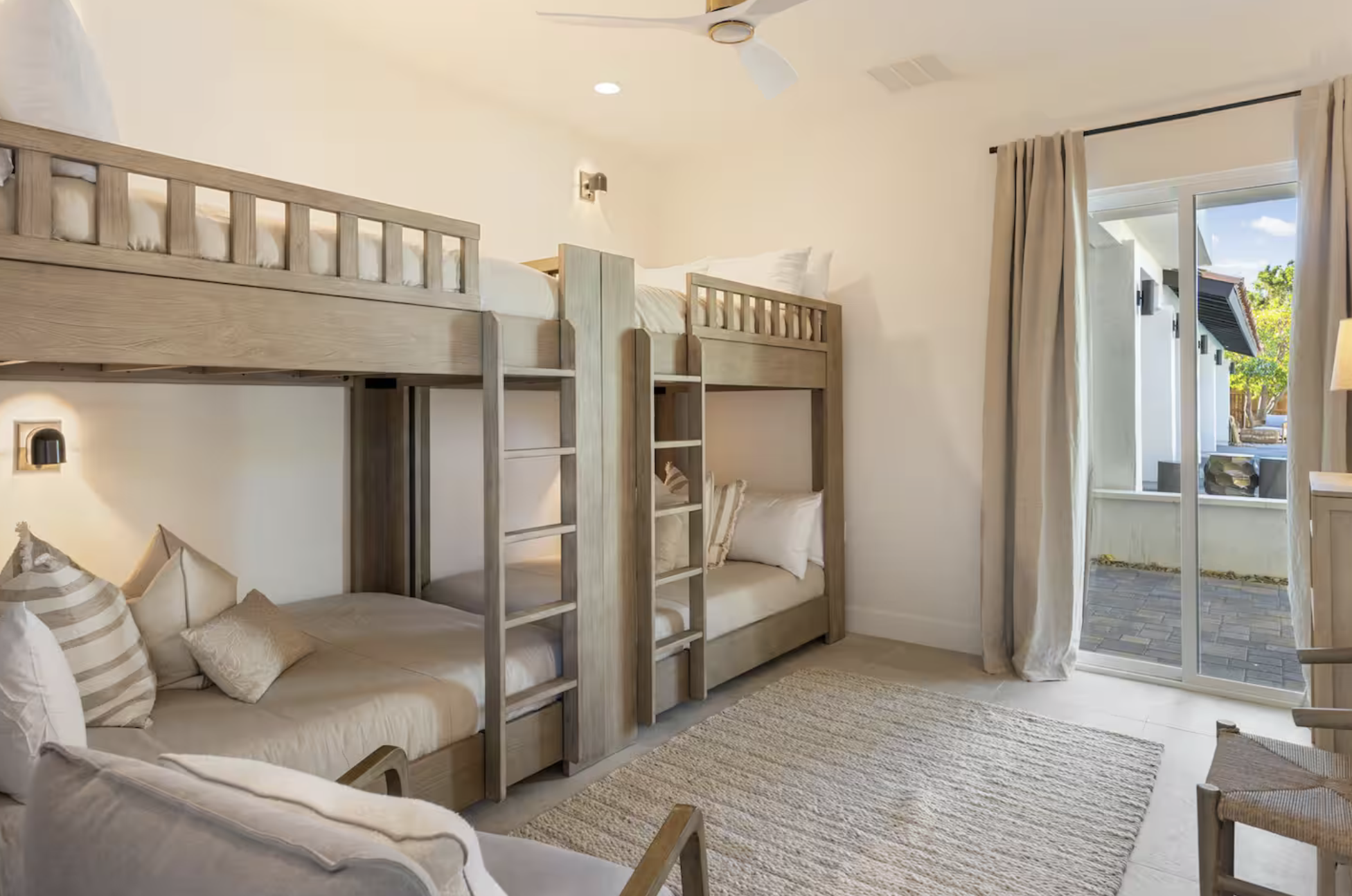 Bedroom with bunk beds, sofa, sliding glass door, and outdoor patio.