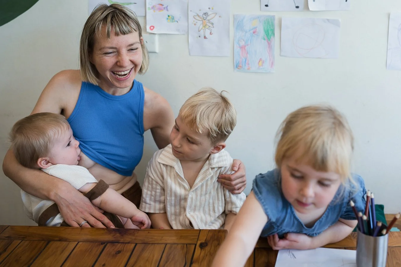 Mother breastfeeding and spending time with her three children during a relaxed in-home family photography session in Melbourne.