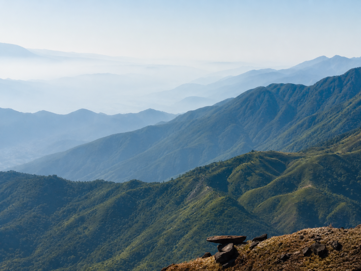 Mountain ridges beneath a clear blue sky, representing perspective, resilience, and personal growth through therapy.