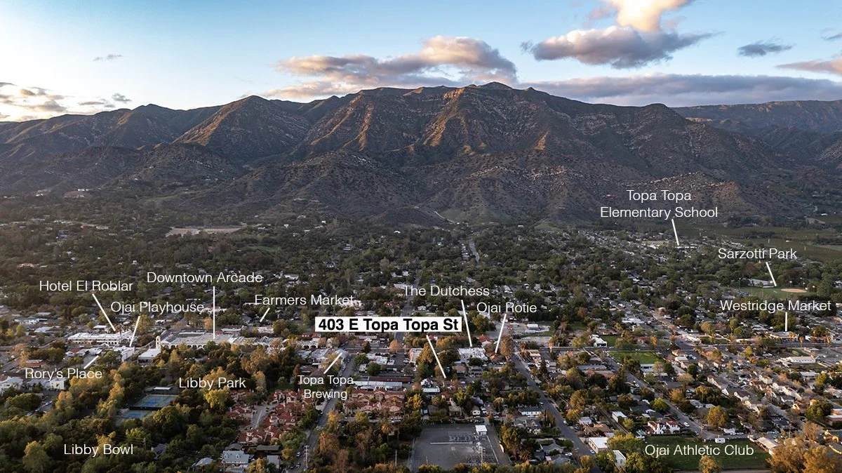 Aerial view of a town with mountains in the background, featuring labels for local landmarks including Hotel El Roblar, Downtown Arcade, Farmers Market, The Dutchess, and Topa Topa Elementary School.