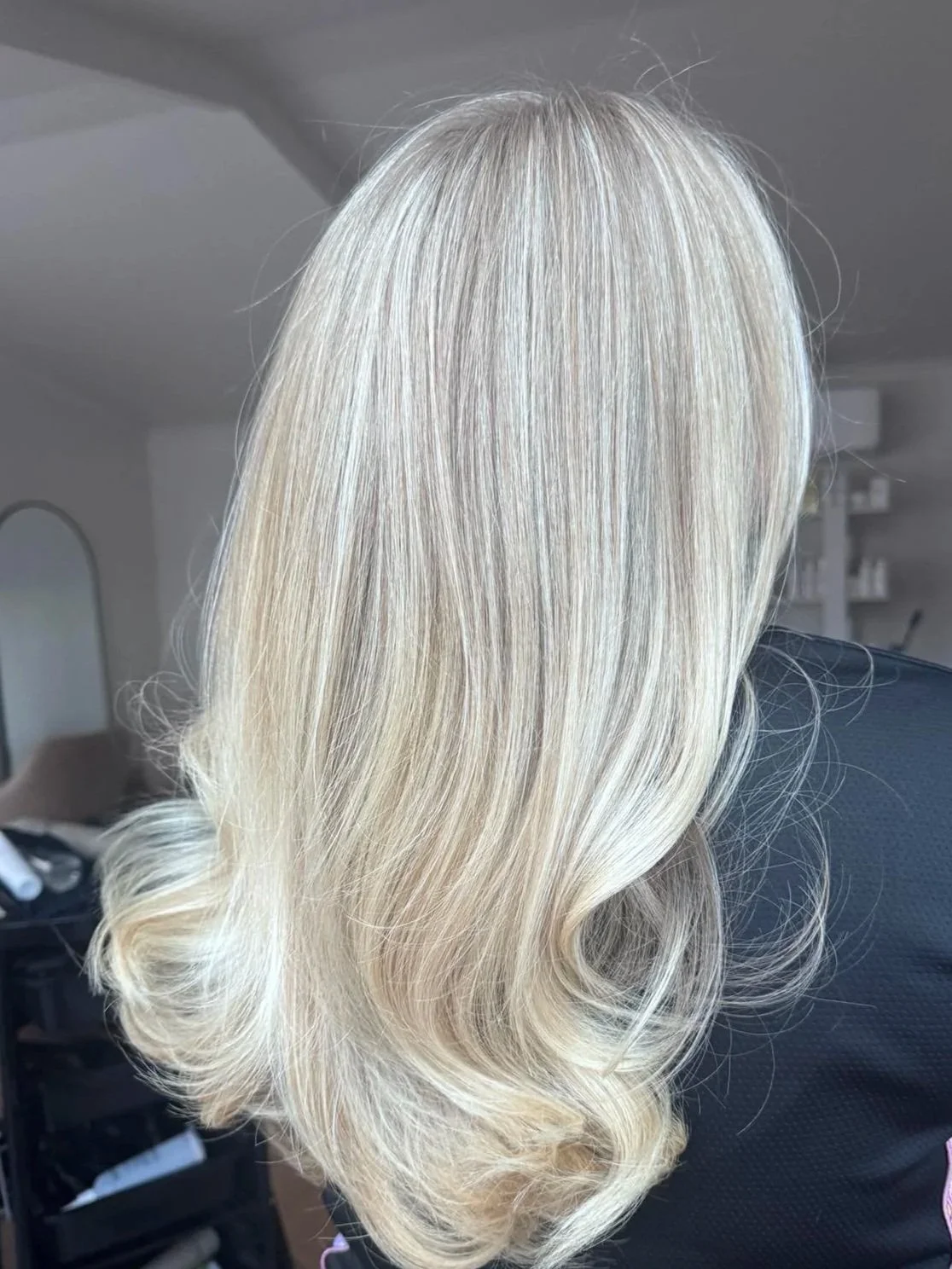 Blonde hair styled in loose curls.