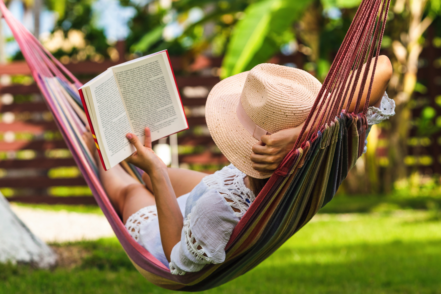 Woman Reading While Relaxing in a Hammock