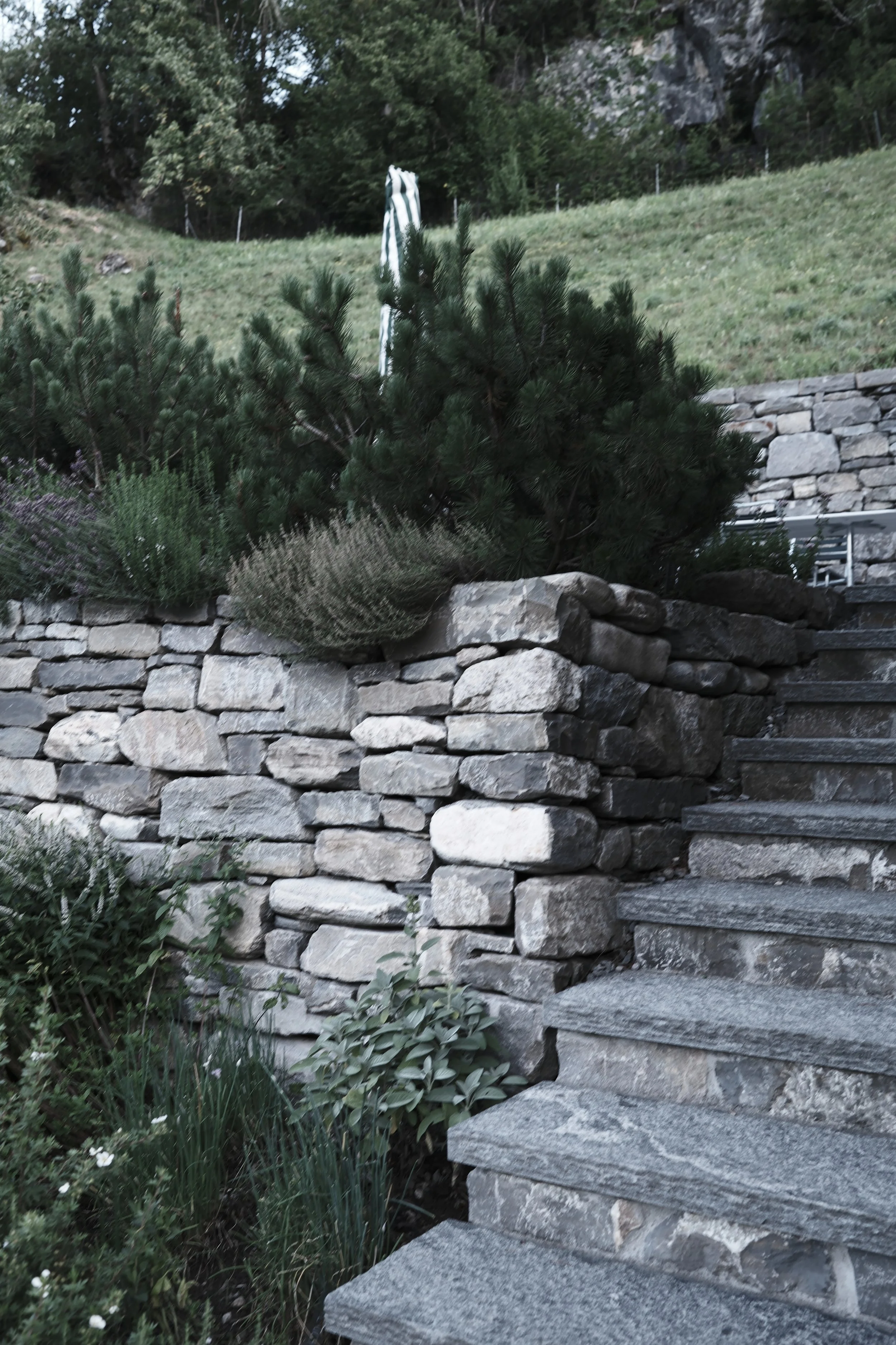 Alt text Private gardens and natural stone terraces at Haus Mannenberg, surrounded by more than 2,000 m² of grounds in Mannried near Gstaad.