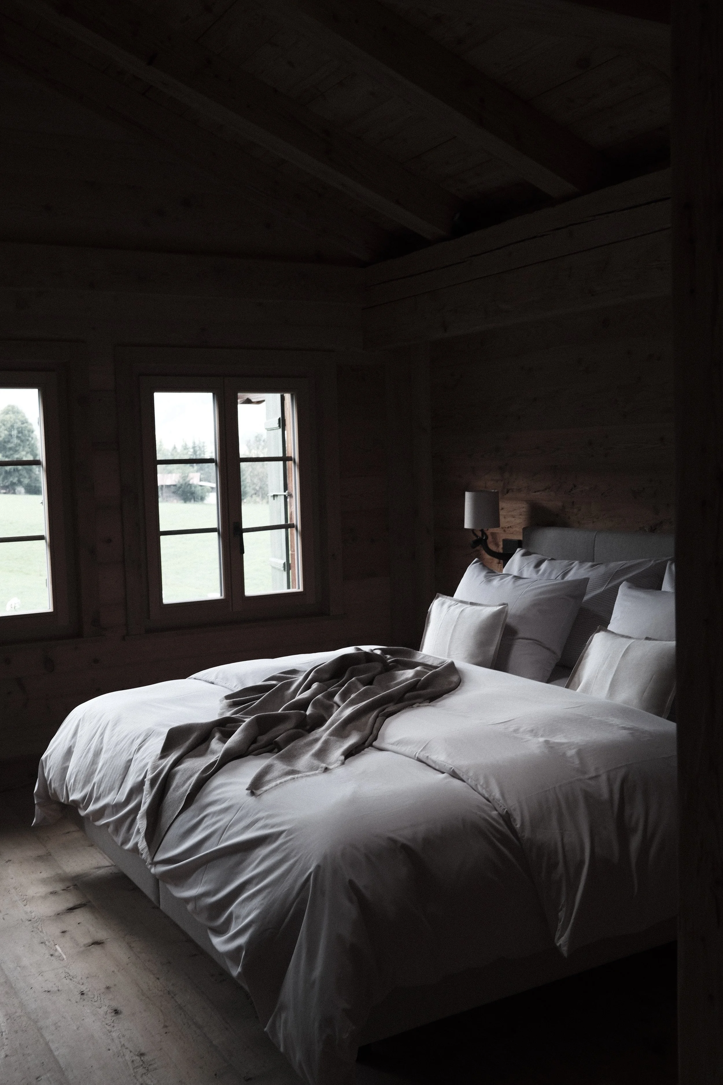 The Morning Room at Haus Mannenberg with a king-size bed, original timber walls and views across the Bernese Oberland.