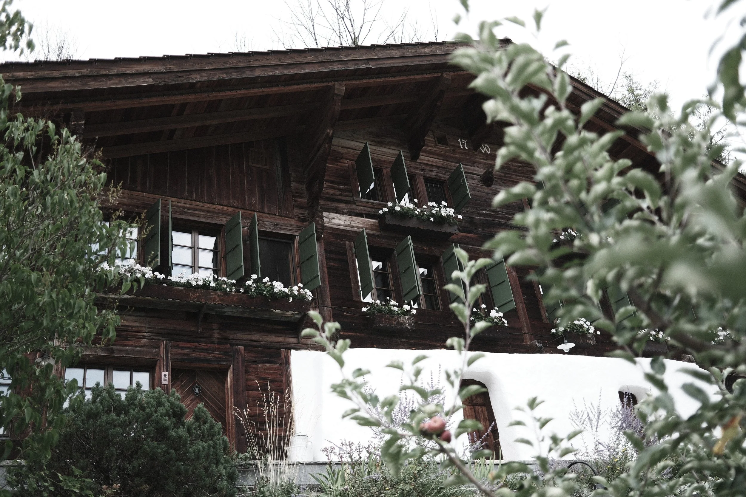 Exterior of Haus Mannenberg, a restored 18th-century historic Swiss chalet in Mannried near Gstaad in the Bernese Oberland.