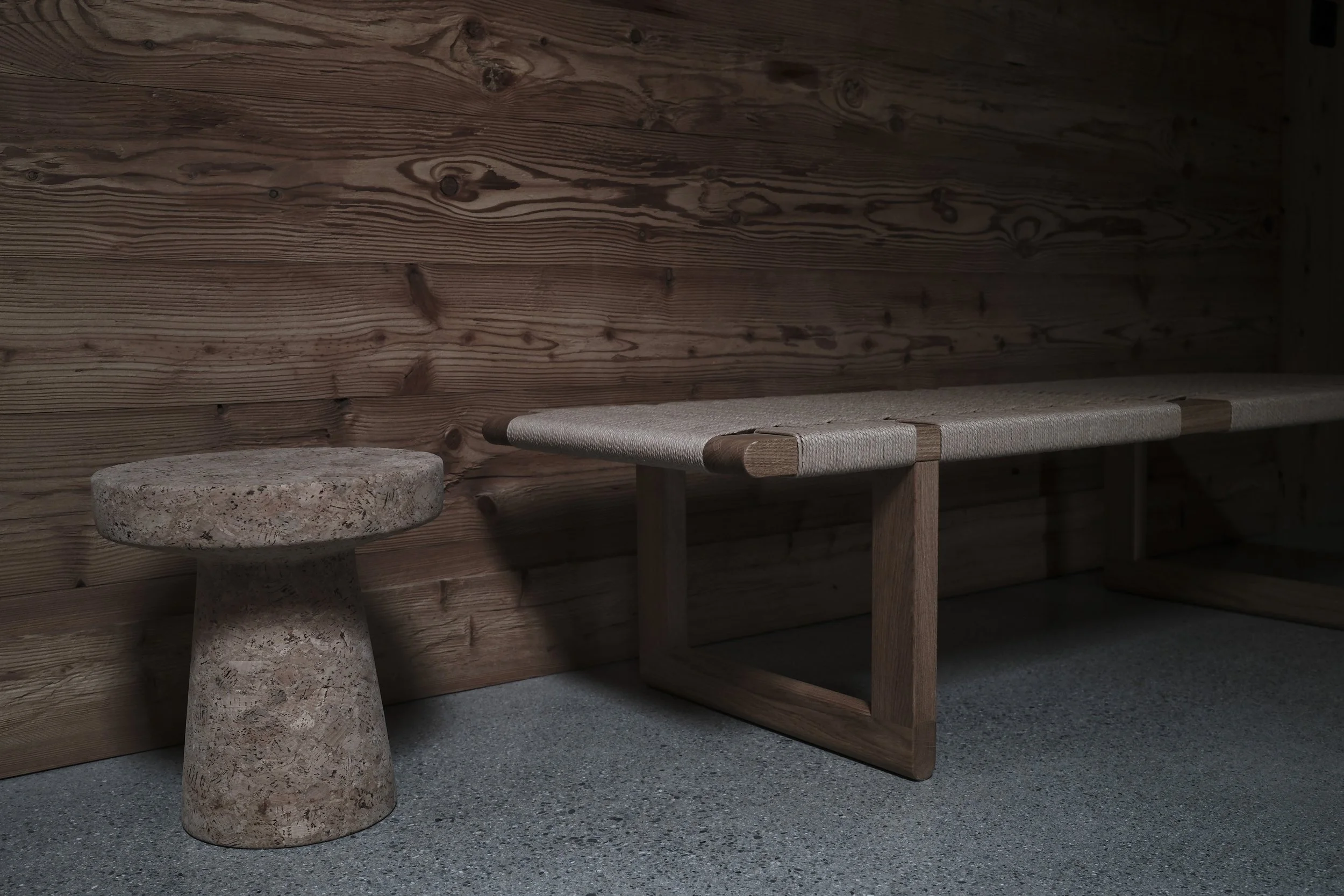 Quiet lounge at Haus Mannenberg featuring Carl Hansen and Vitra furniture, handcrafted stone seating and original timber walls in a restored Swiss chalet.
