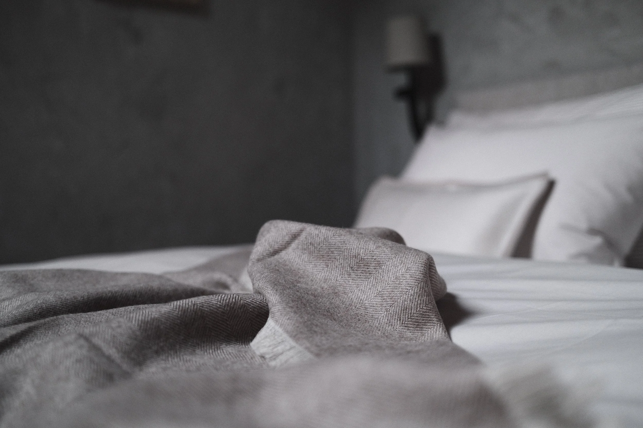 King-size bed with natural linen bedding in a thoughtfully designed guest room at Haus Mannenberg.