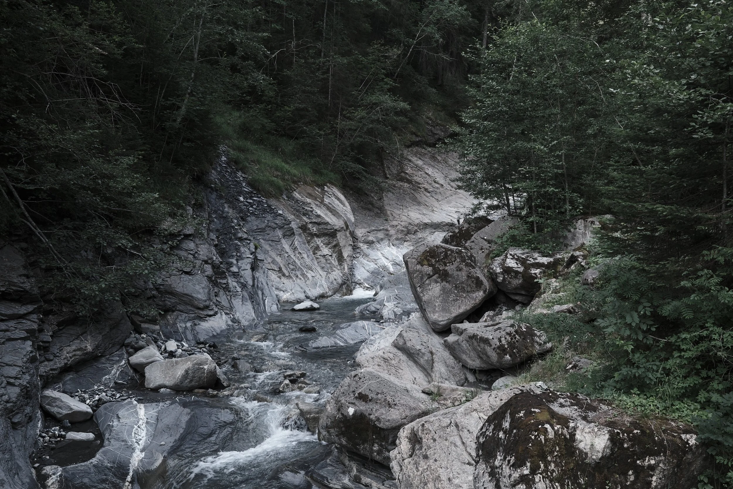 Natural ice bath in Mannried near Haus Mannenberg, where crystal-clear alpine water flows through a quiet gorge in the Bernese Oberland.