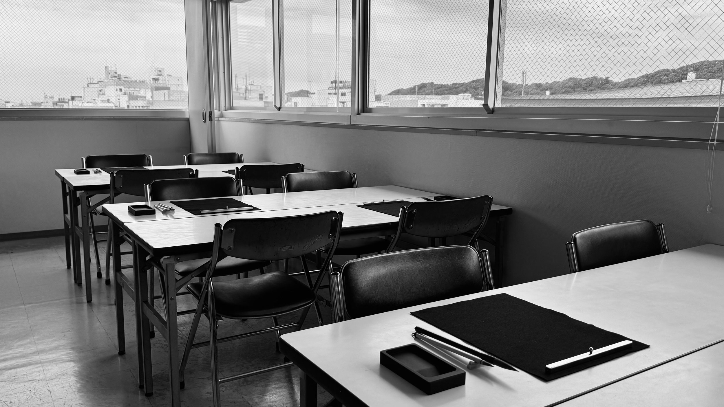 書道教室の明るいレッスン風景と、机や椅子、書道道具の配置